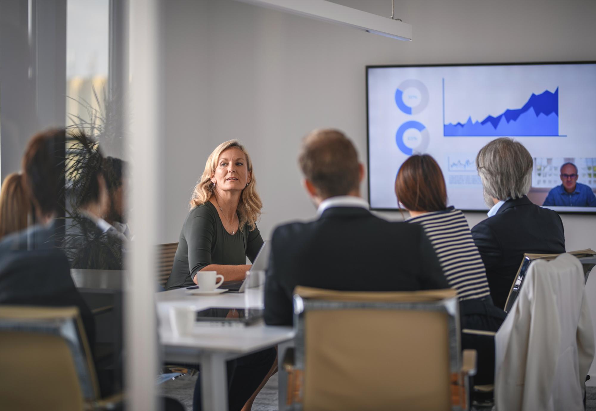 Female leader in conversation with colleagues during a board meeting