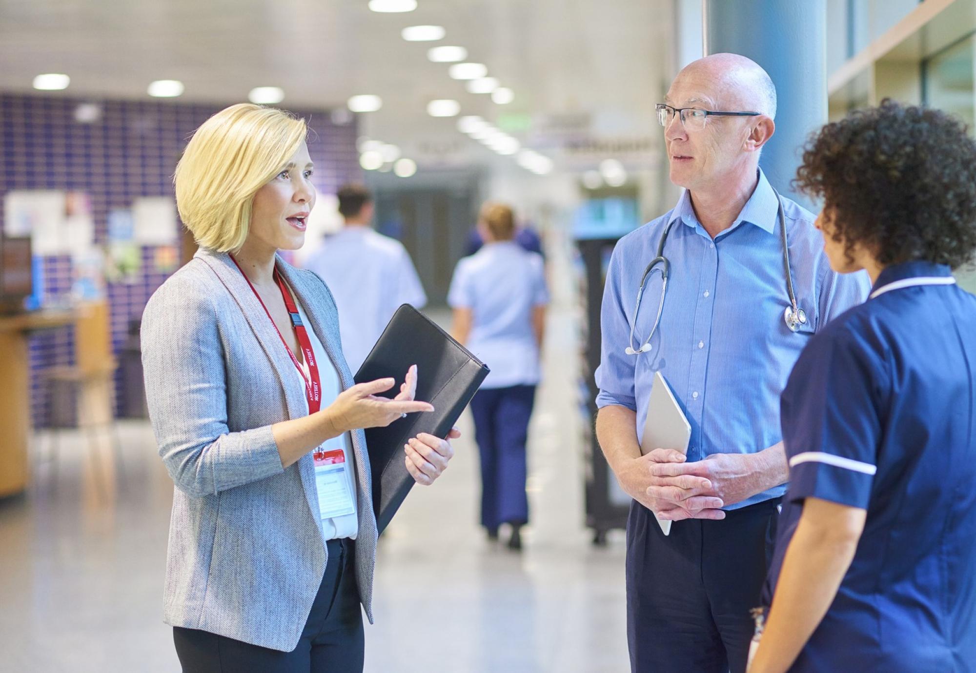 Hospital administrator in discussion with a doctor and nurse