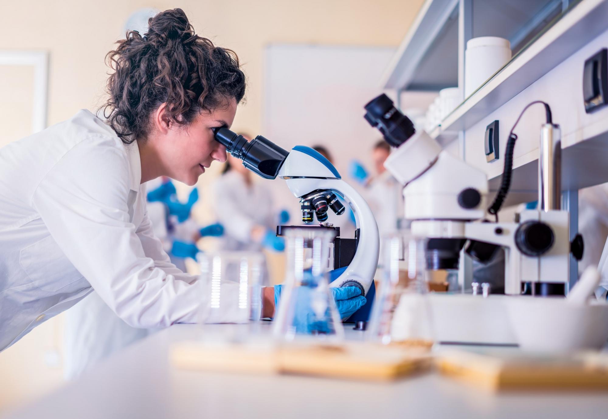 Lab technician operating a microscope