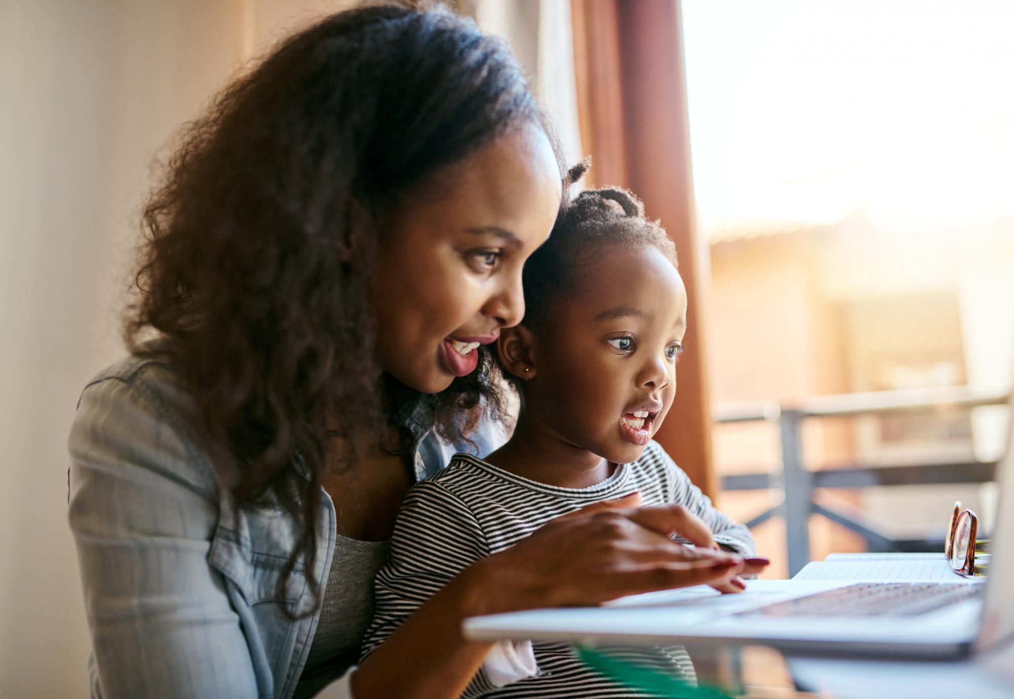 Young mother and her child looking at something on a laptop