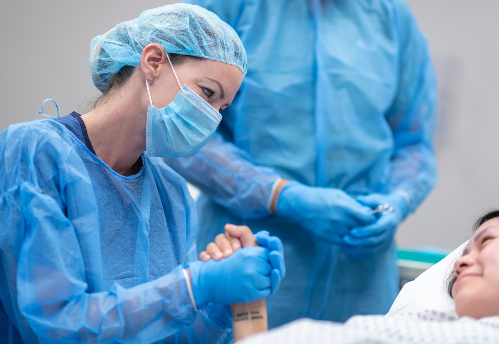 Health professional holding a female patient's hand