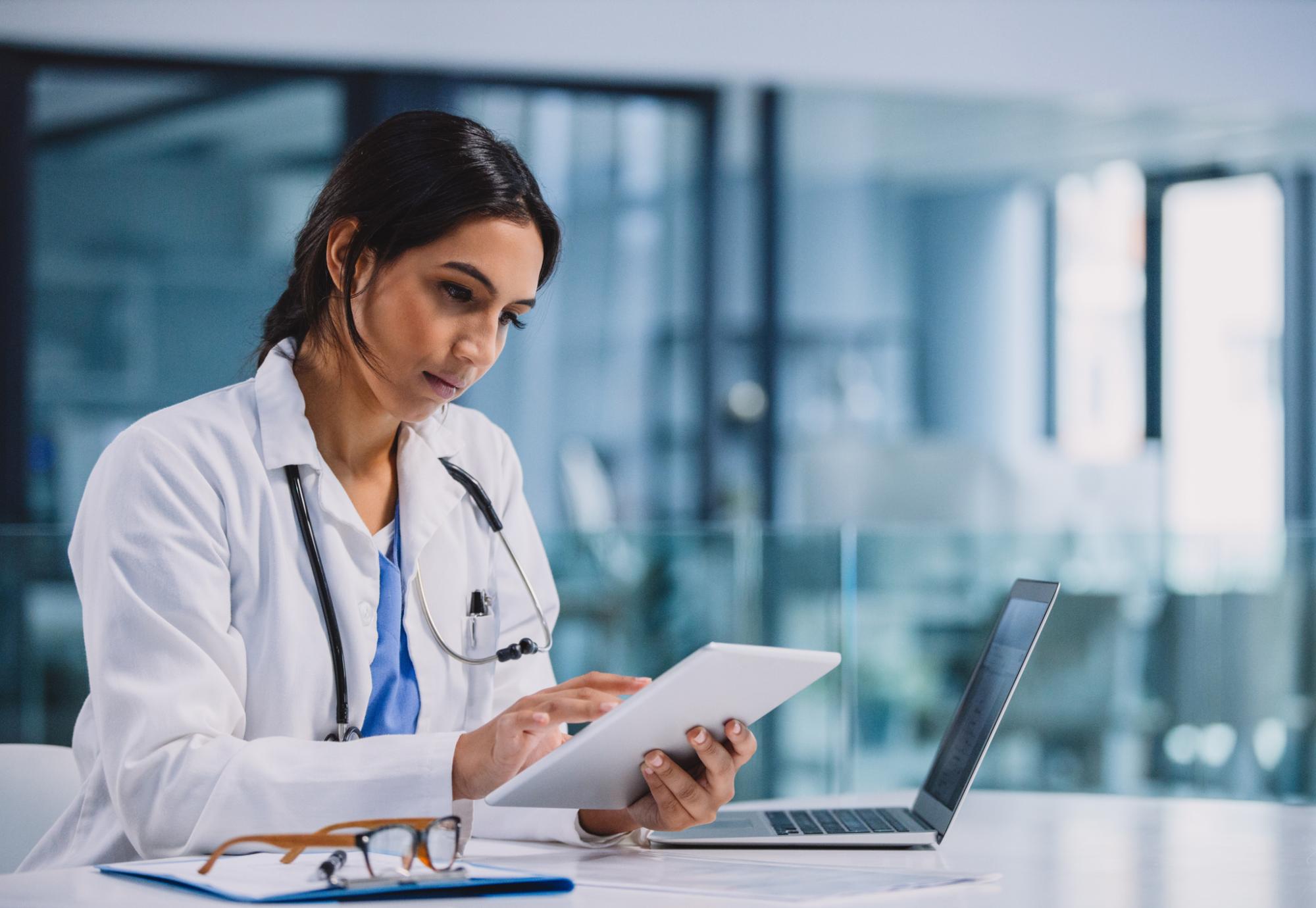 Female doctor using a tablet computer to manager her daily tasks