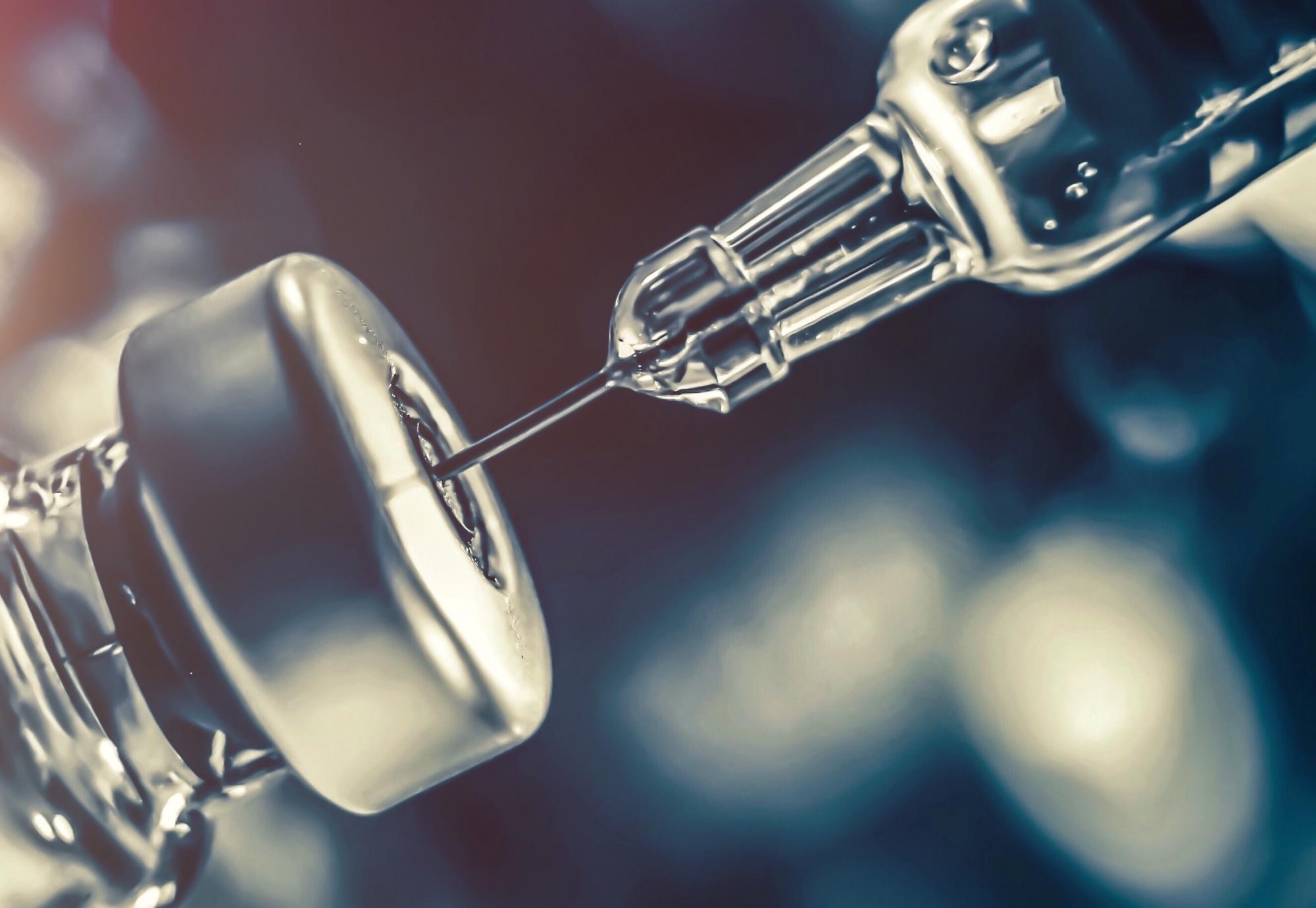 Vaccine bottle being filled with a needle