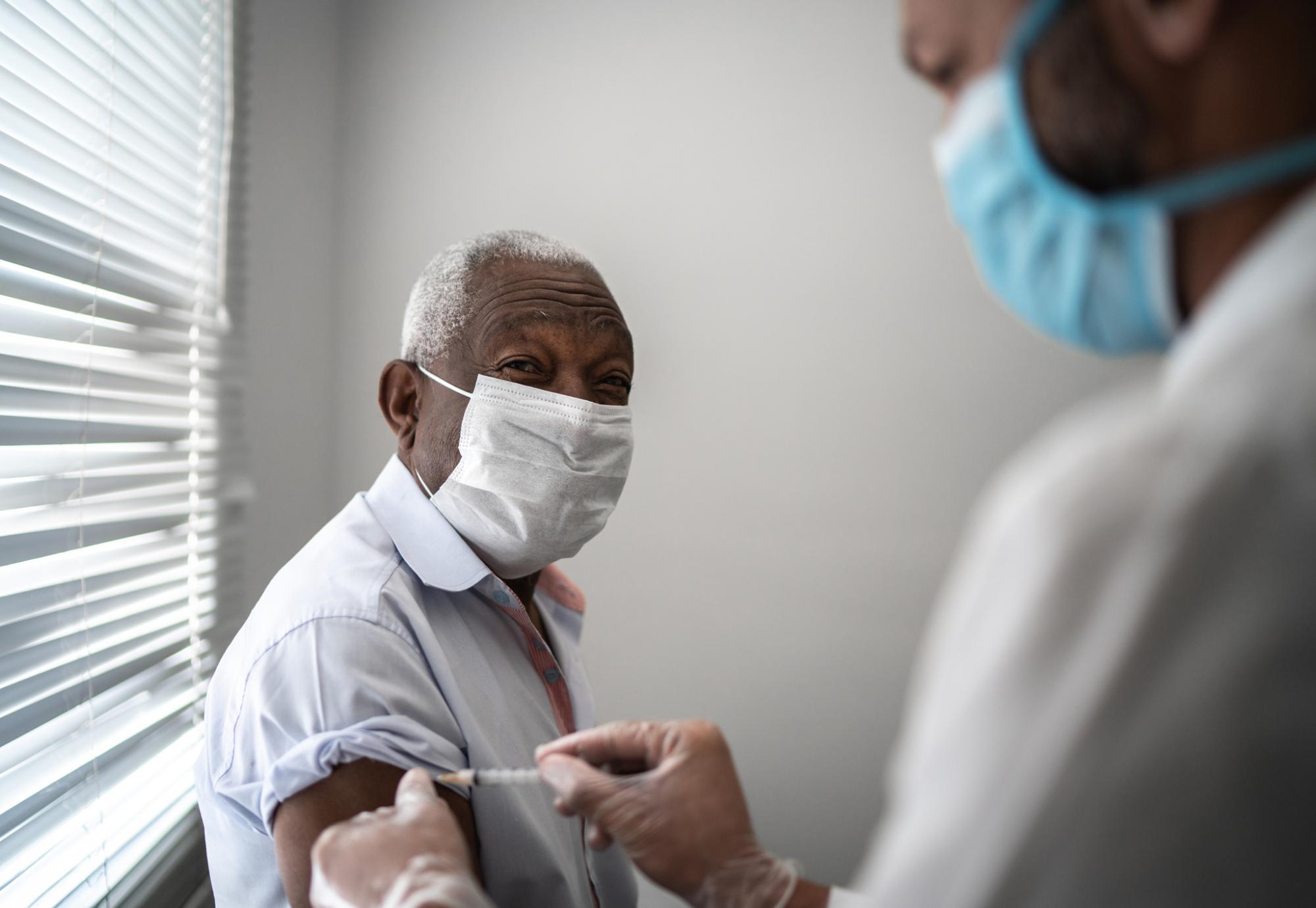 Elderly man receives a vaccine jab