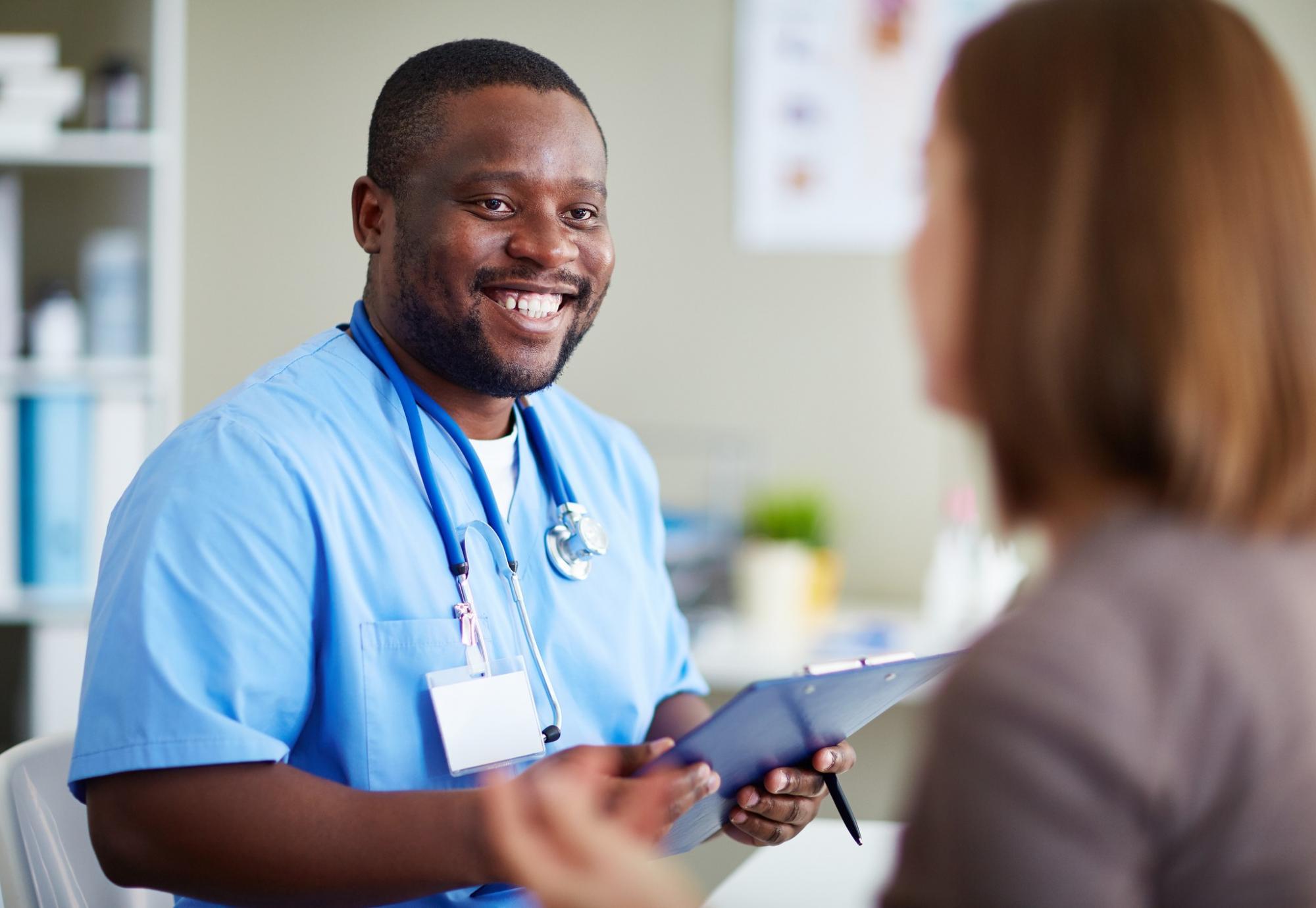 Male nurse holding a clipboard and having a conversation