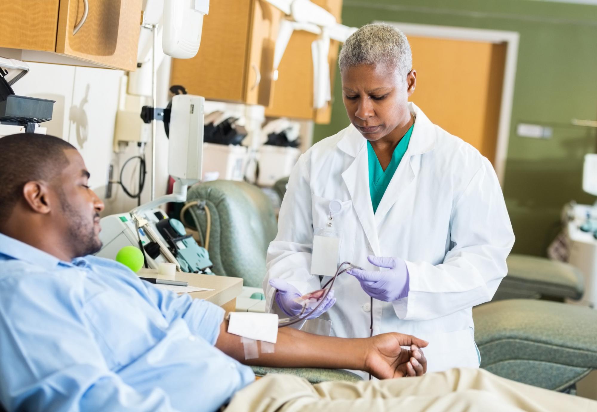 Male patient donating plasma with health professional observing