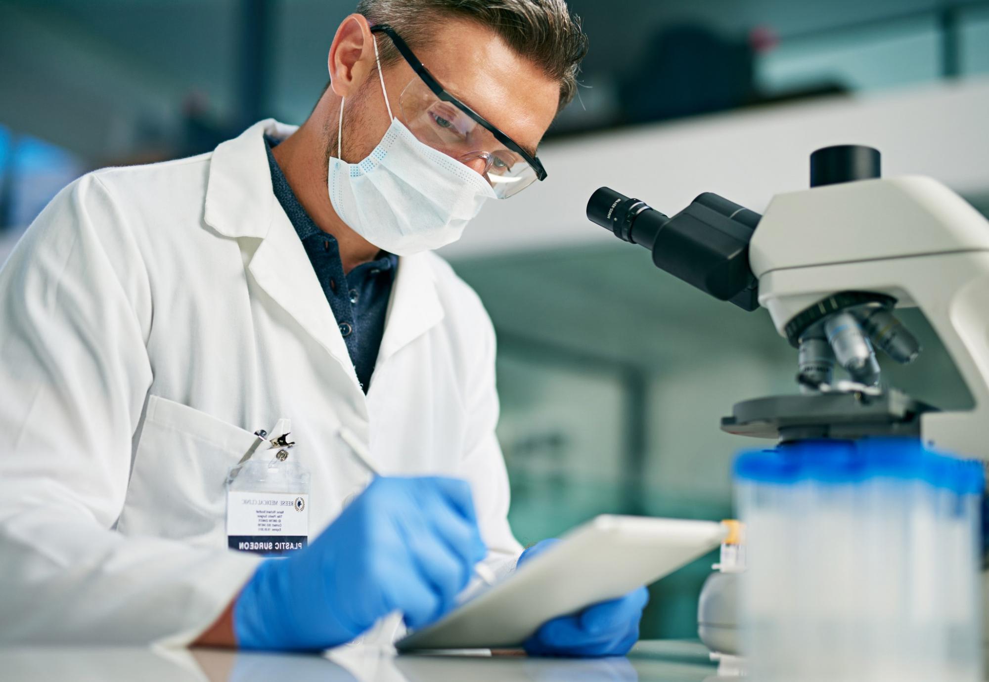 Scientist using a tablet computer in a lab setting