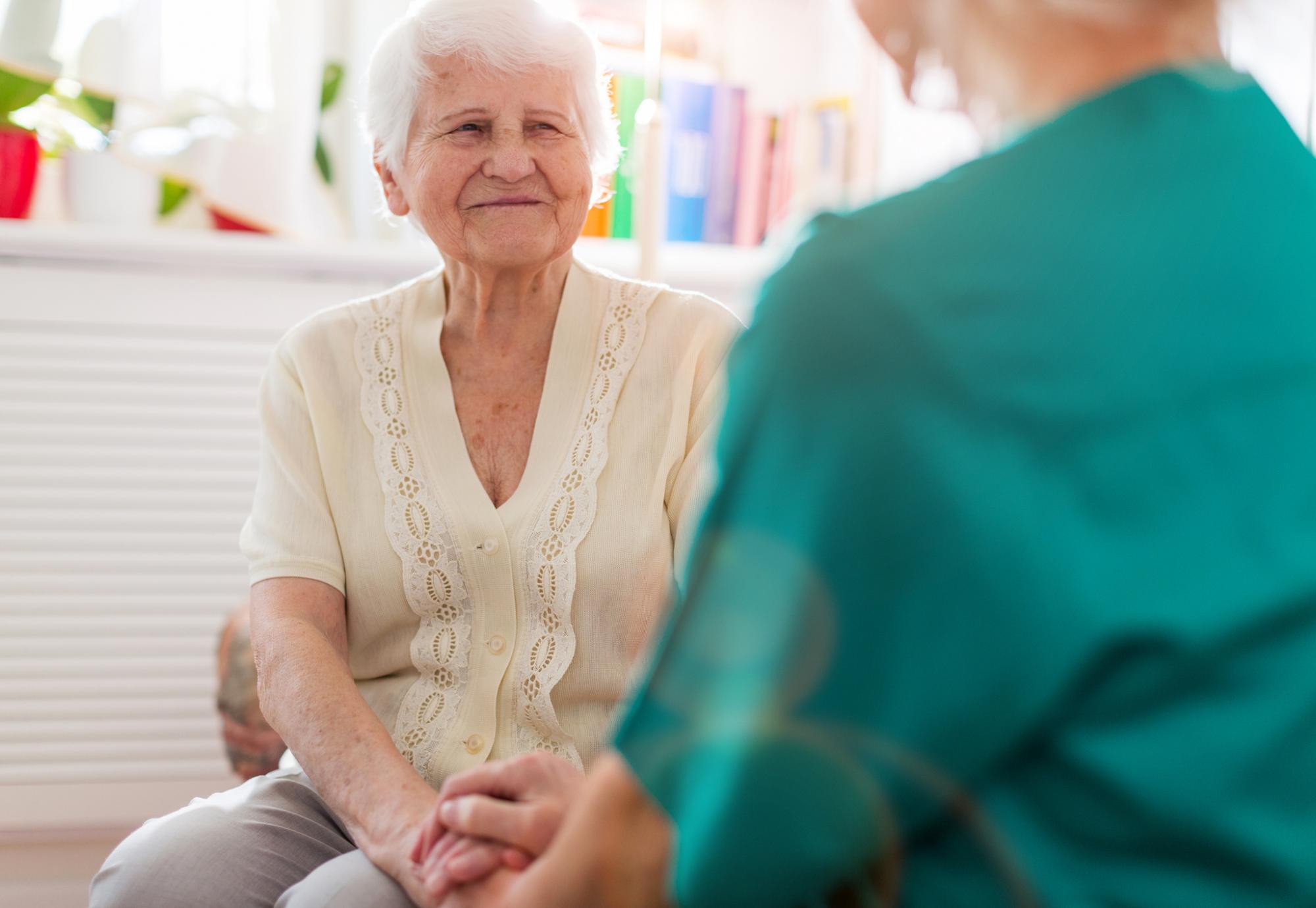 Elderly care home resident in conversation with a nurse