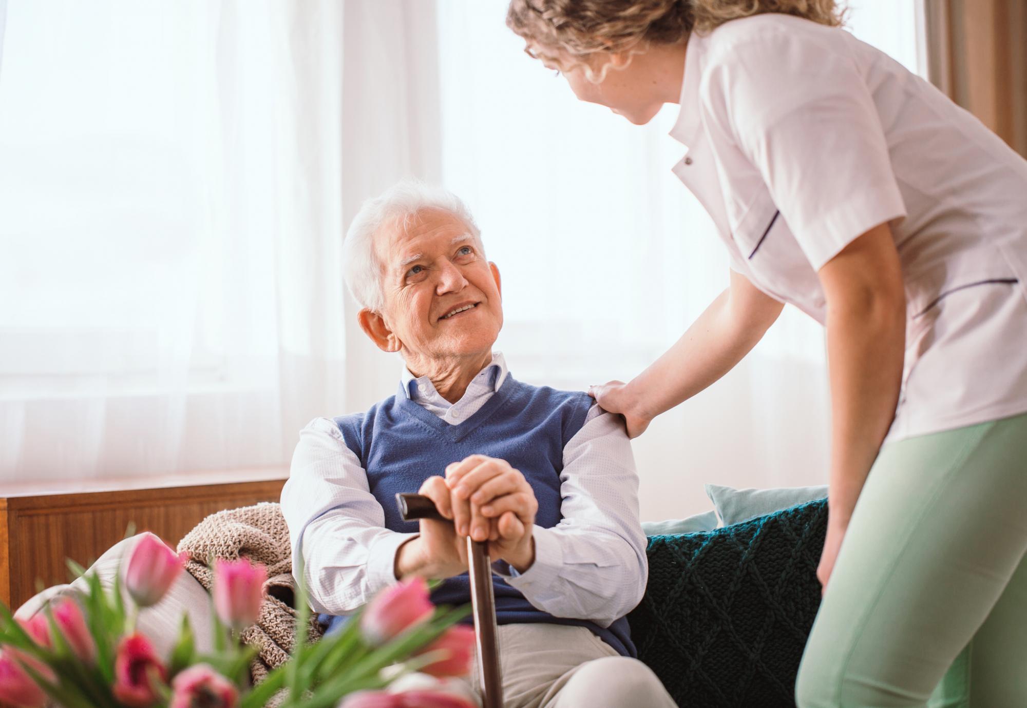 Elderly man being supported by a member of staff