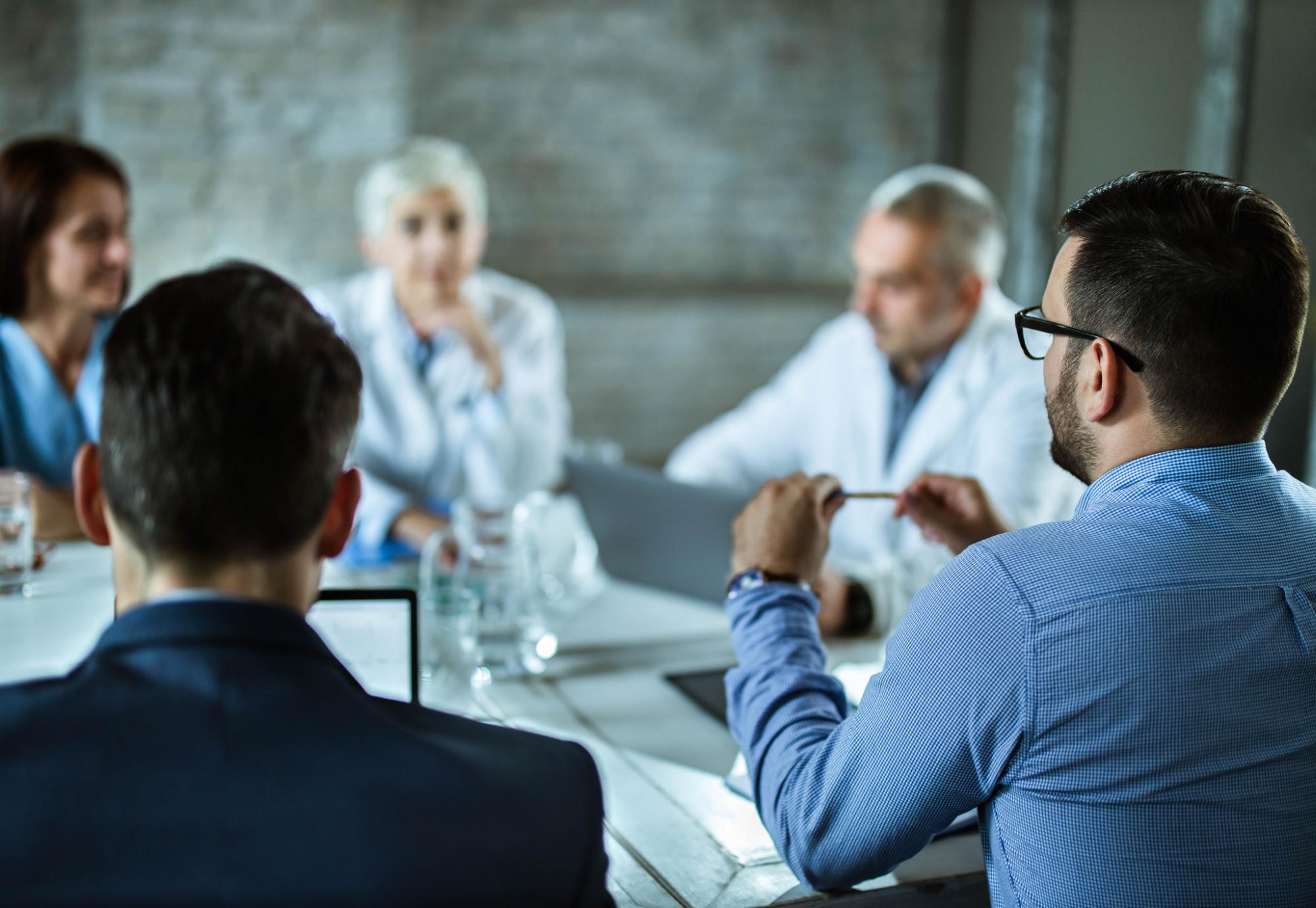 Health meeting discussing around a boardroom table