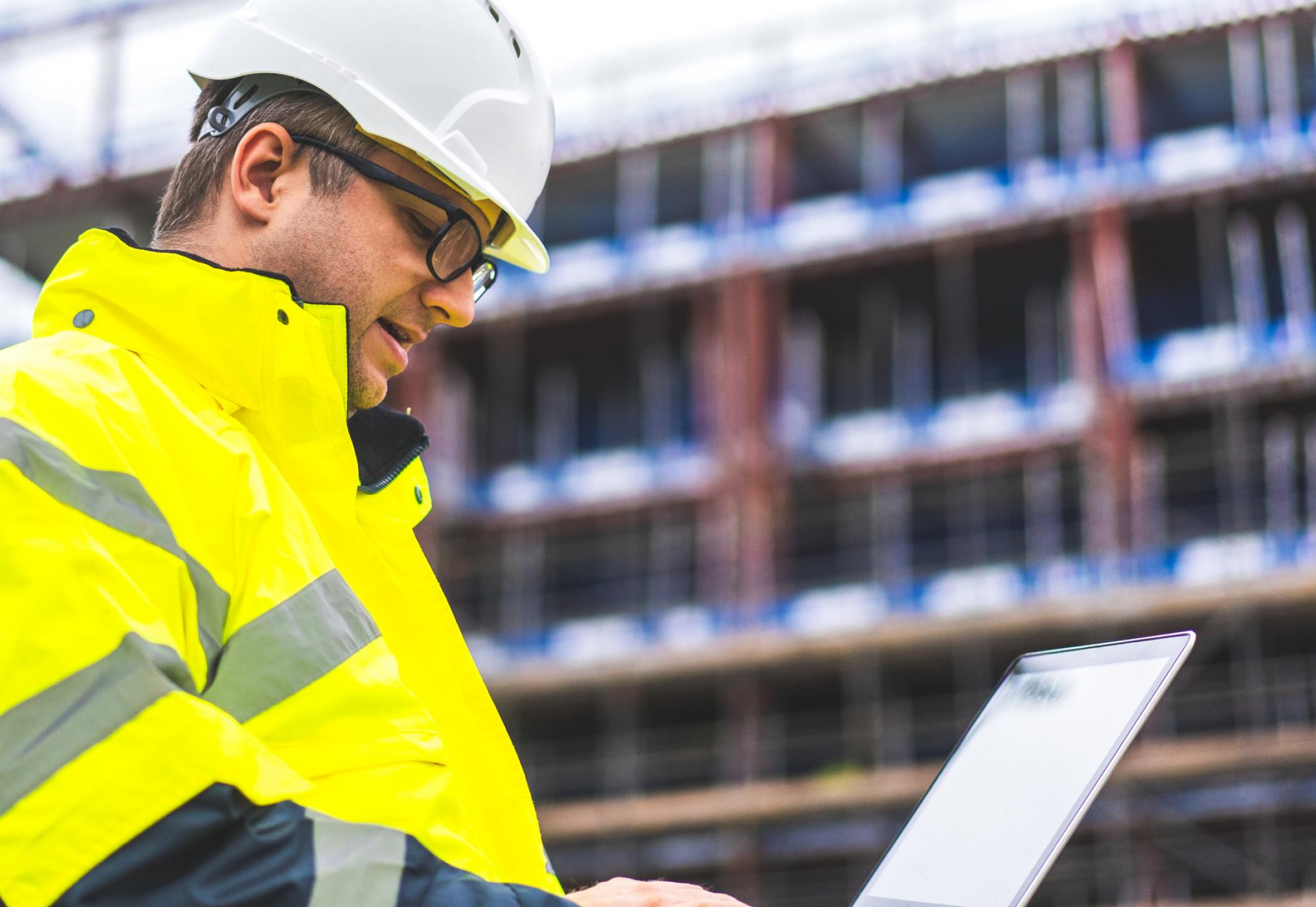 Construction worker looking at plans on a building site