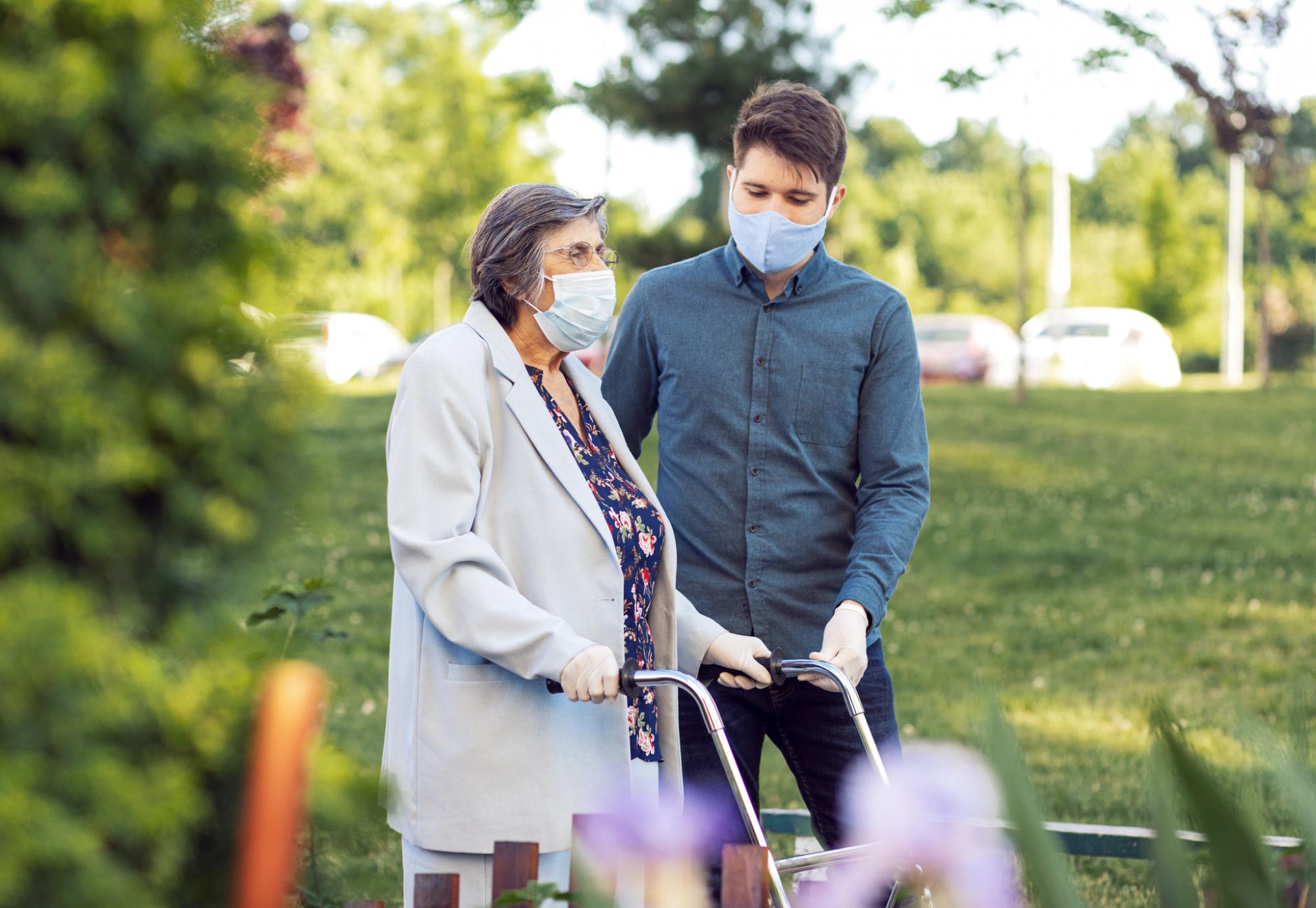 Young man helping elderly care home resident