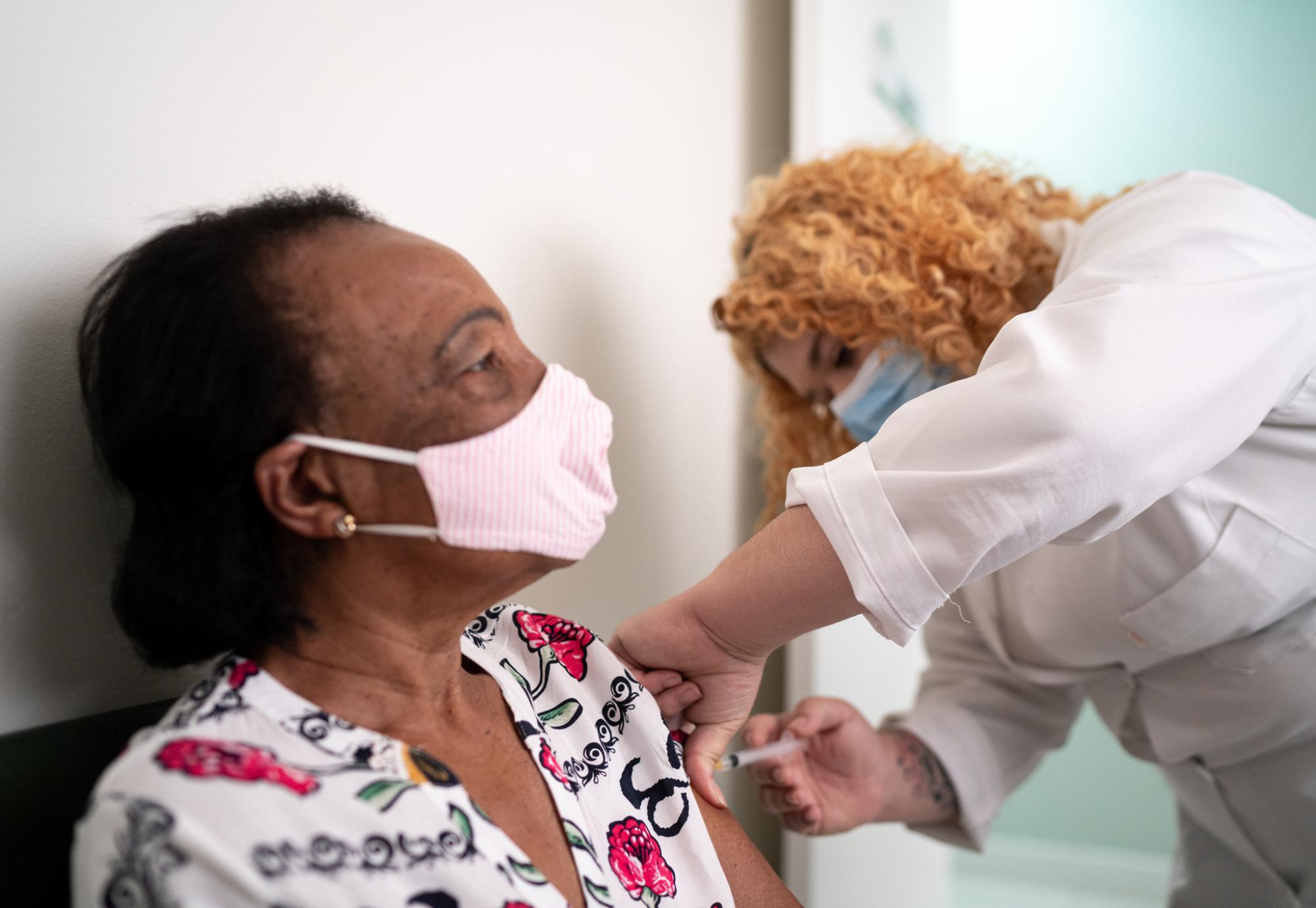 Older woman receiving a vaccine jab