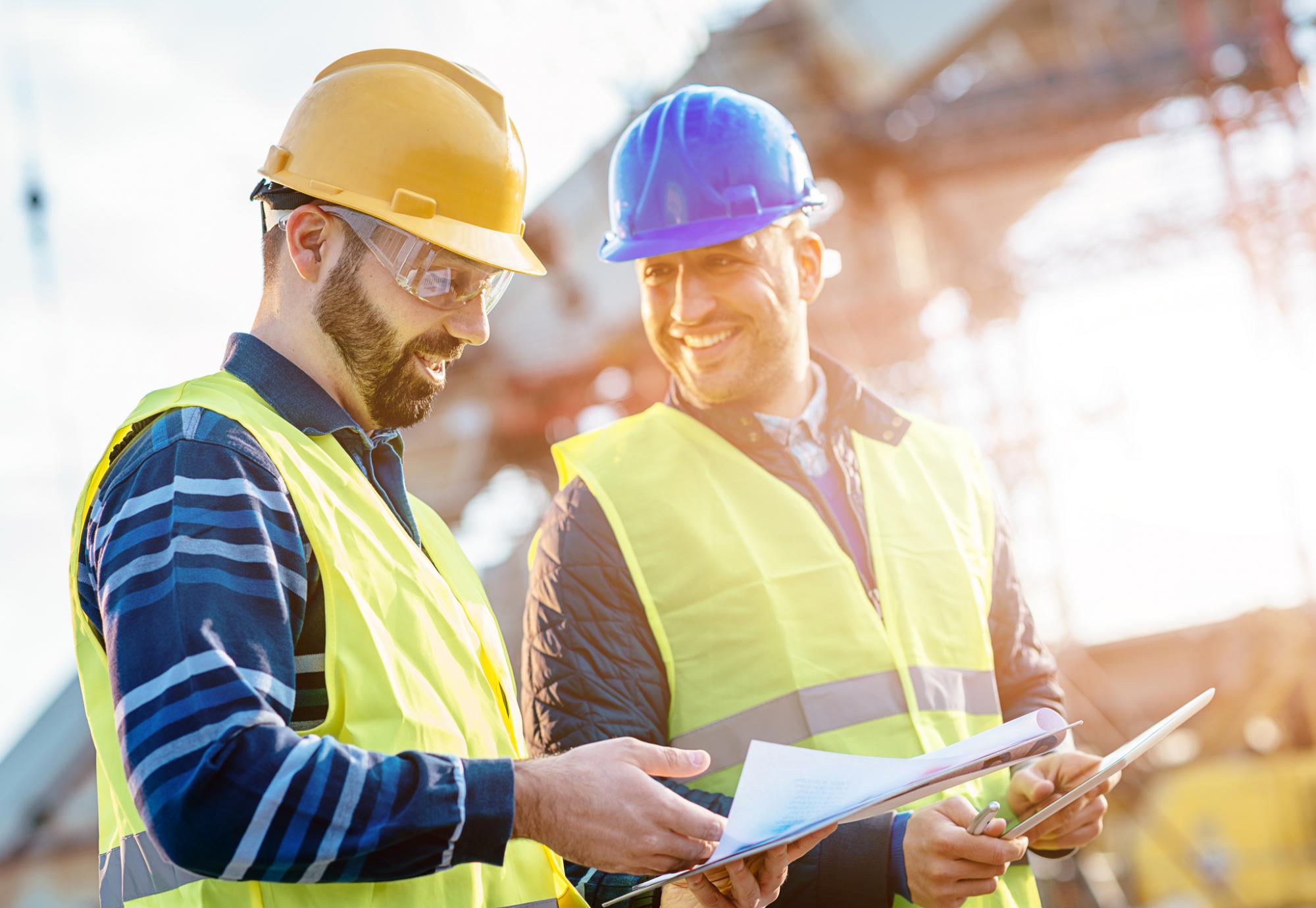 Two builders referring to plans and talking