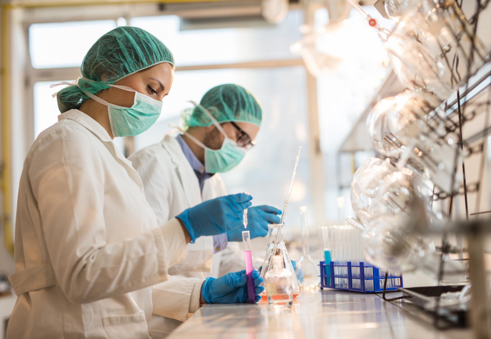 Two lab workers using medical research equipment