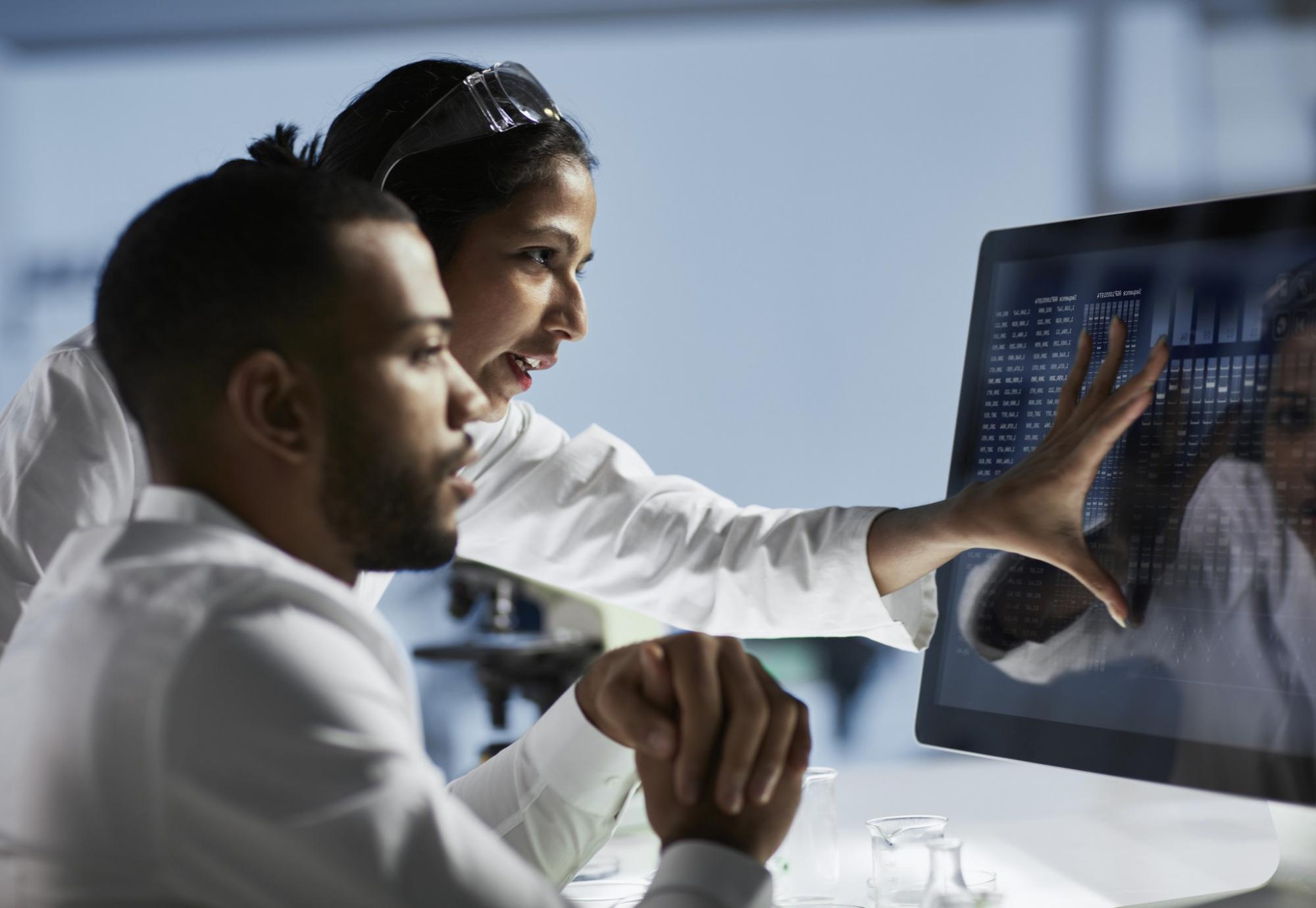 Medical researchers reviewing data on a screen