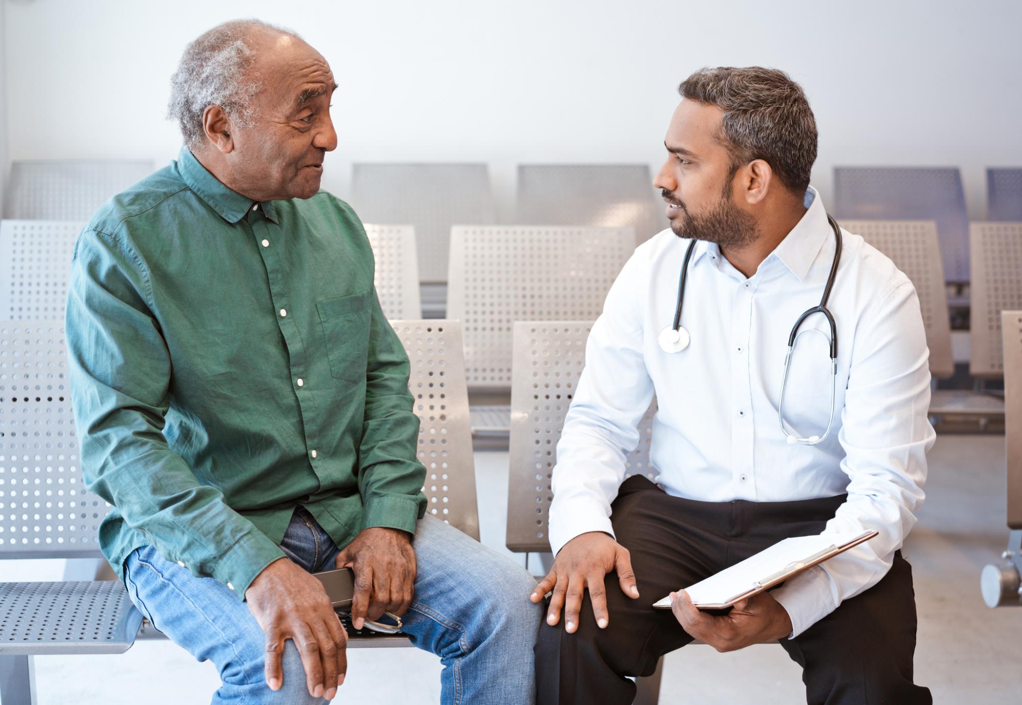 Man of South Asian descent talking with a doctor