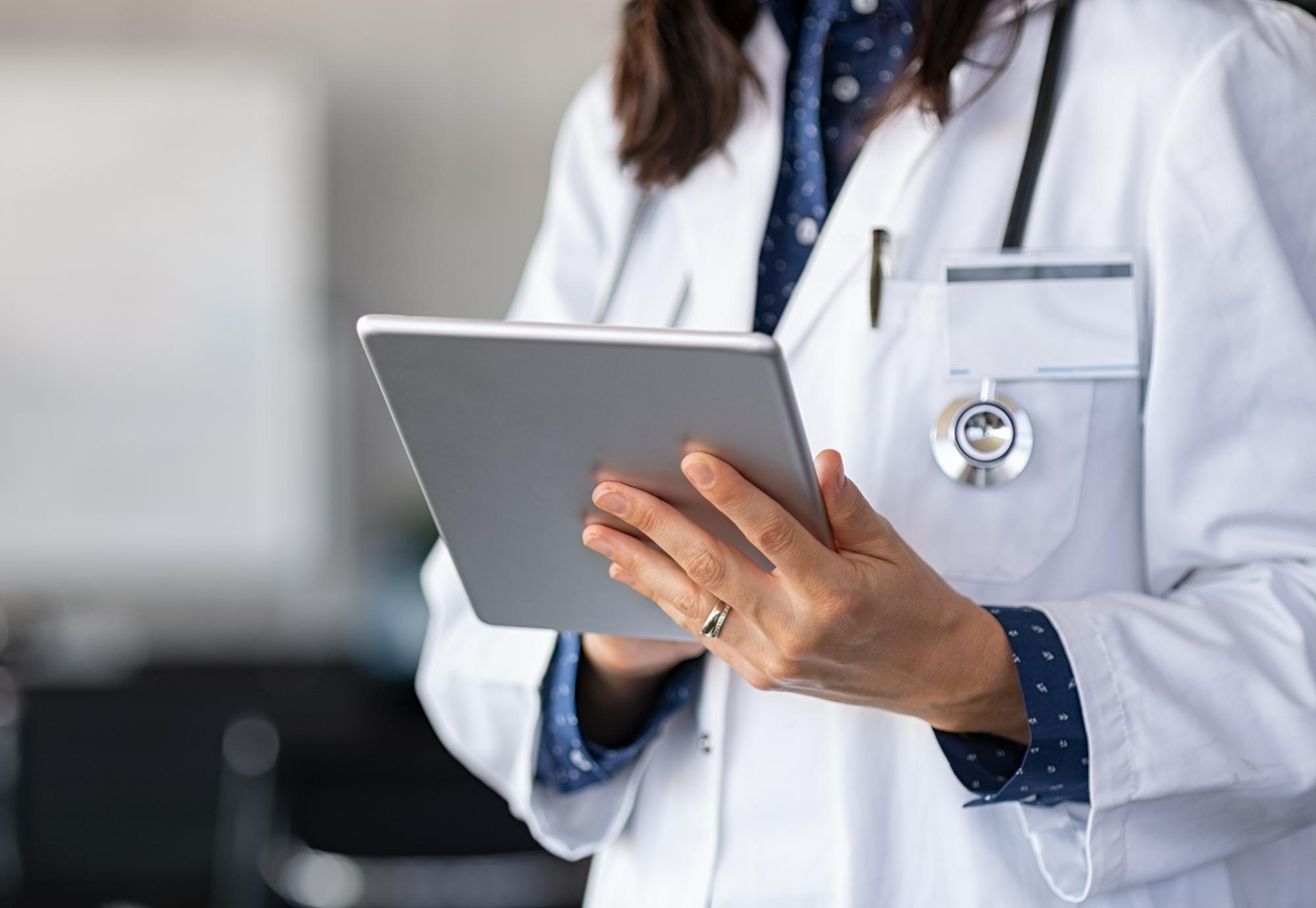 Doctor using a tablet PC to update records