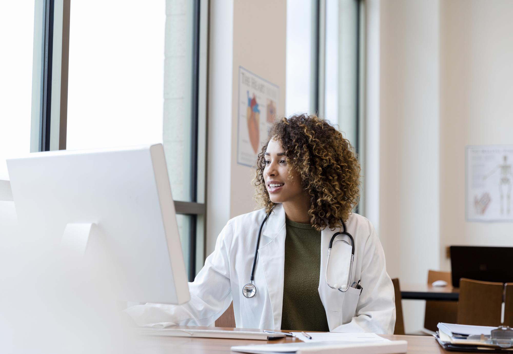 Doctor using a large desktop PC