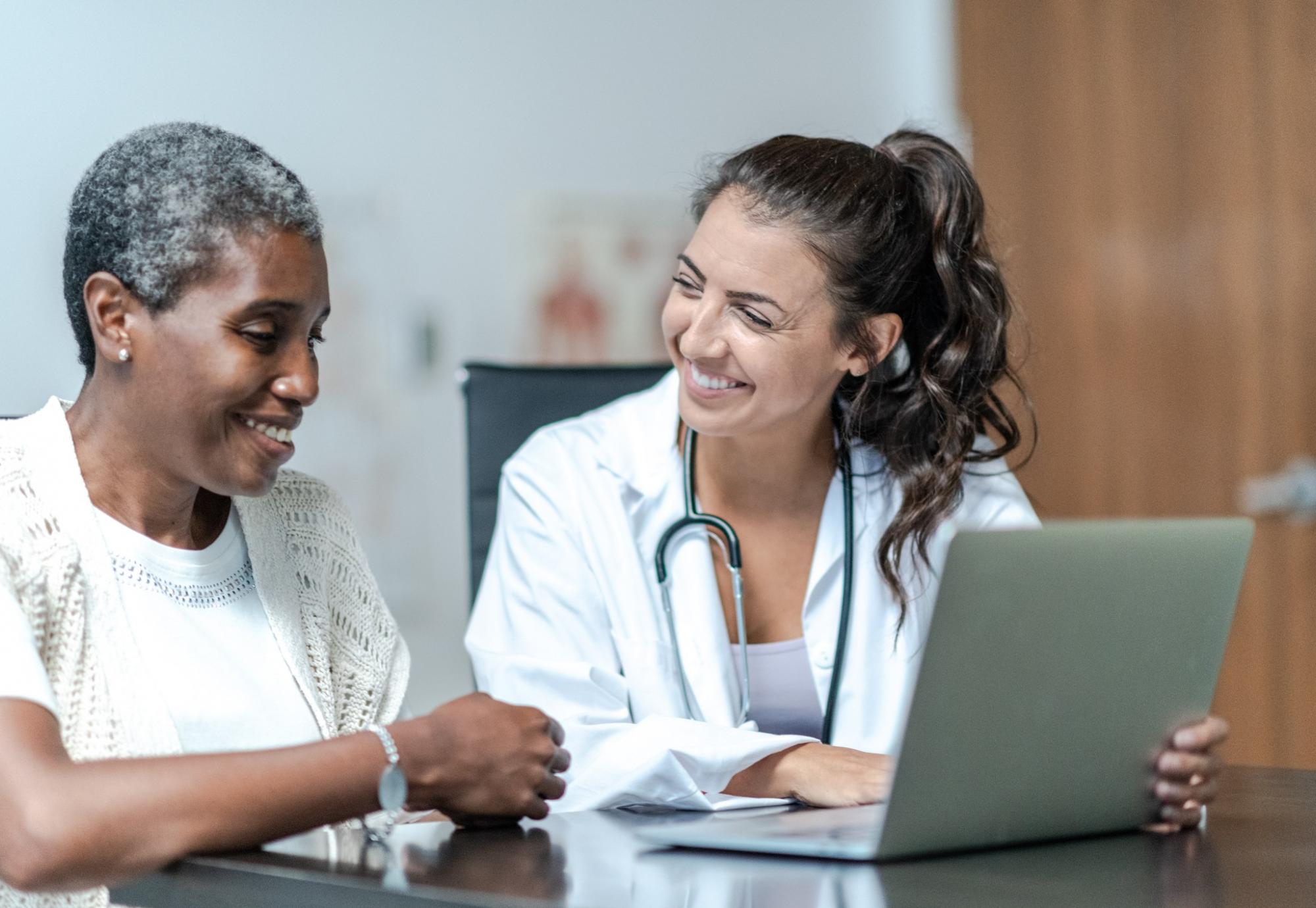 Female doctor discussing with a female patient about their care