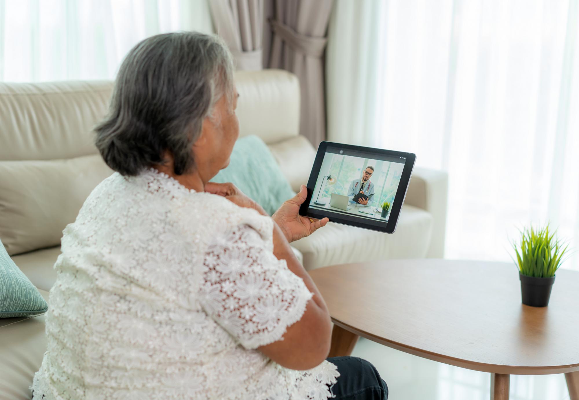 Elderly woman in conversation with a doctor on a tablet PC