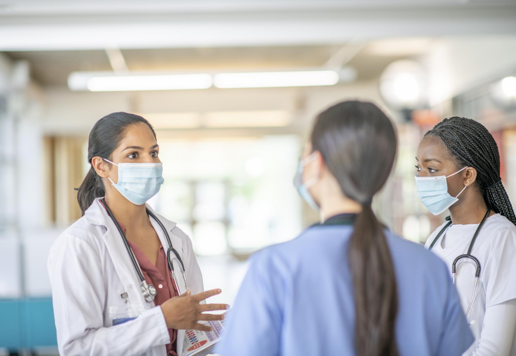 Medical professionals discussing while on a ward