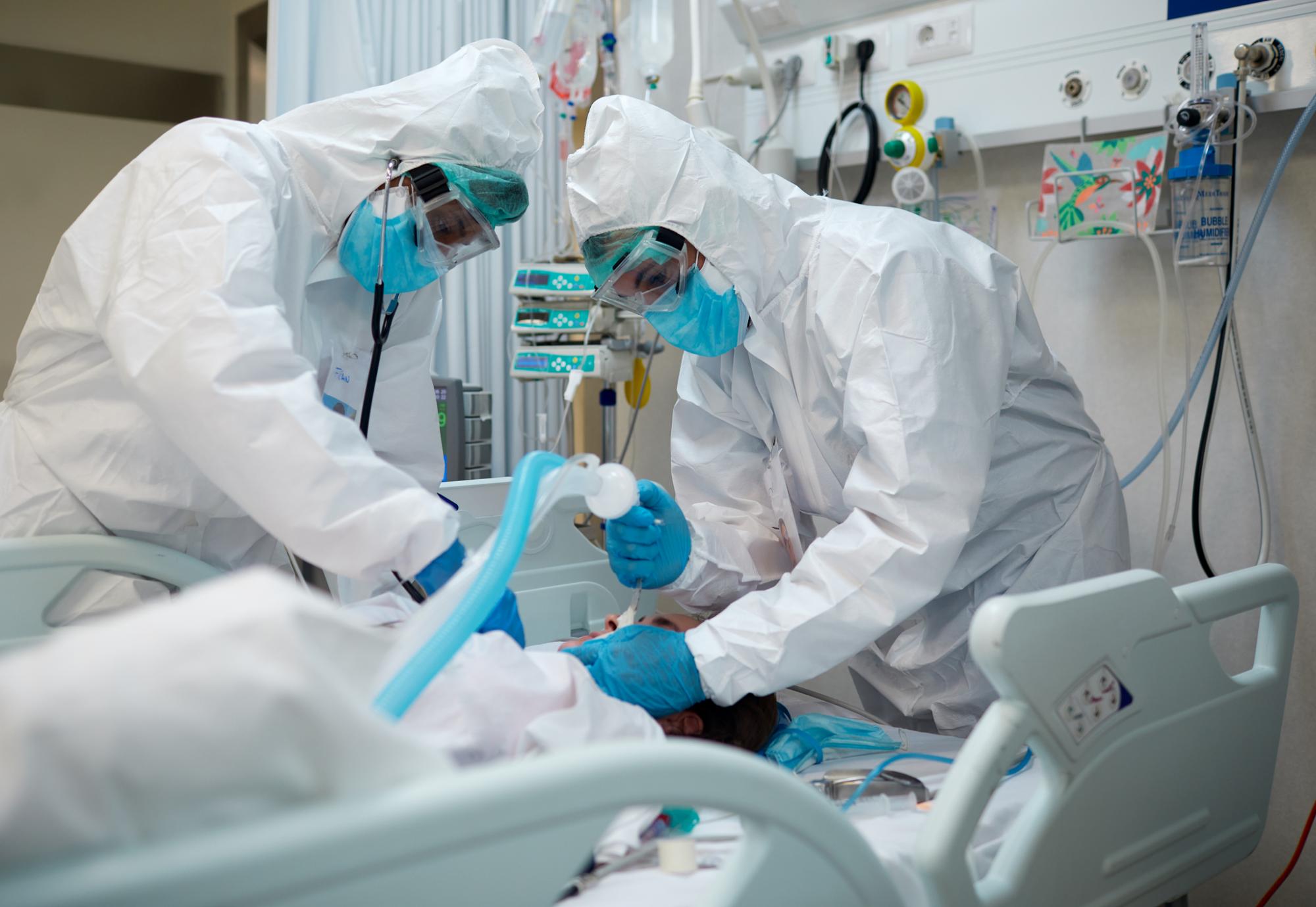 Health workers in PPE intubating a patient