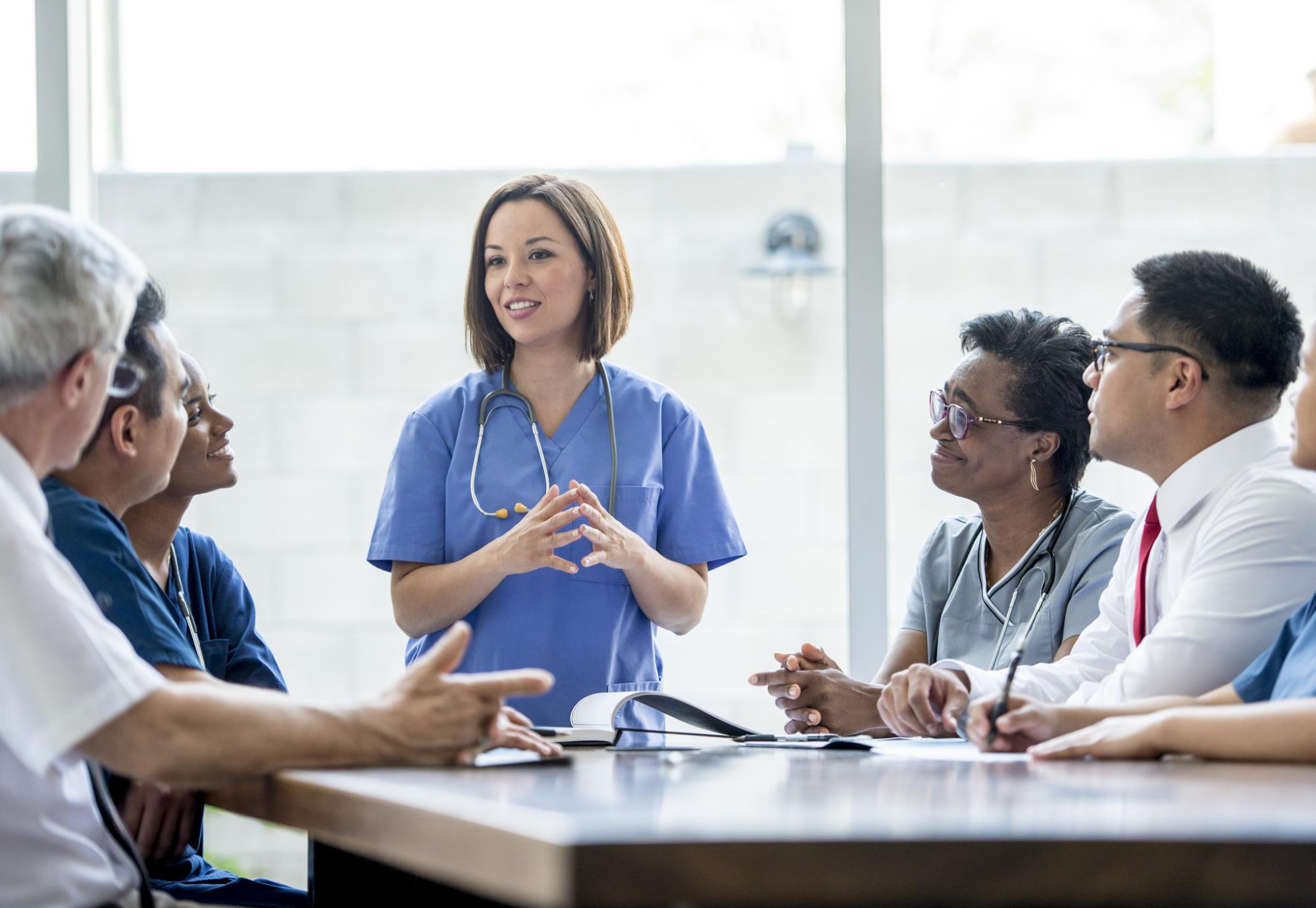 Female nurse presenting to a group of health professional colleagues