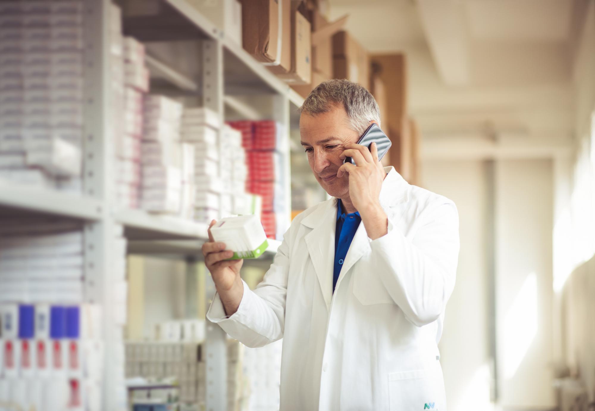 Pharmacist sorting a medical drug from a shelf