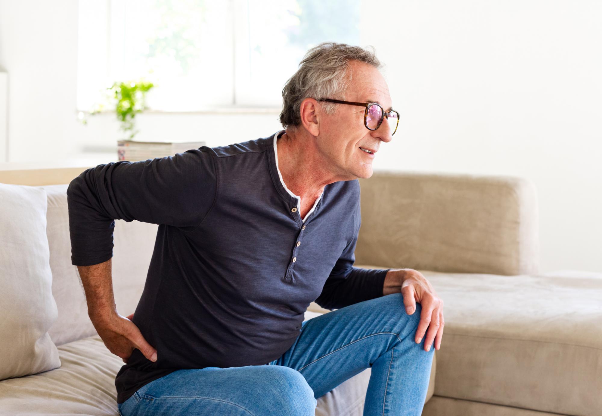 Older man holding his back due to pain