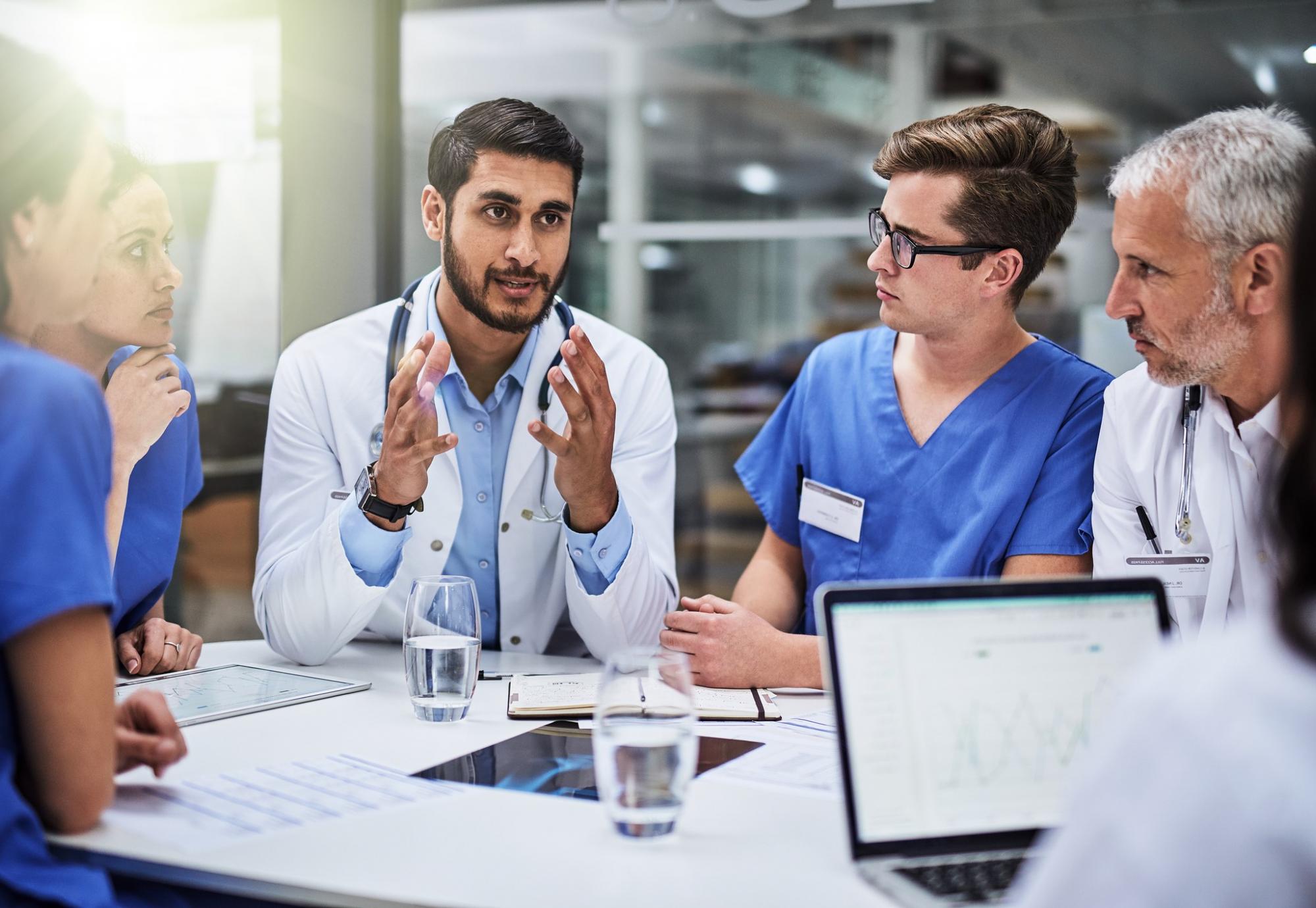 Young doctor discusses with a team of health professionals