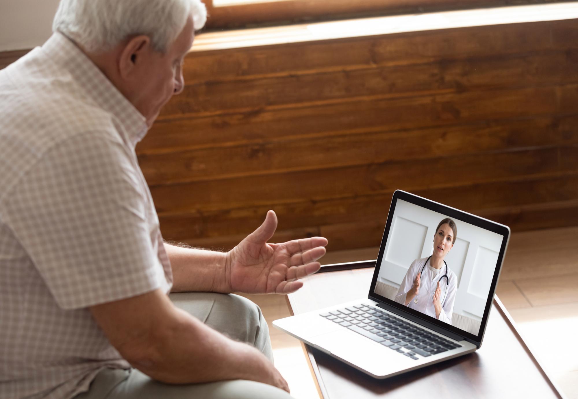 Older man talking with a medical professional on a video call