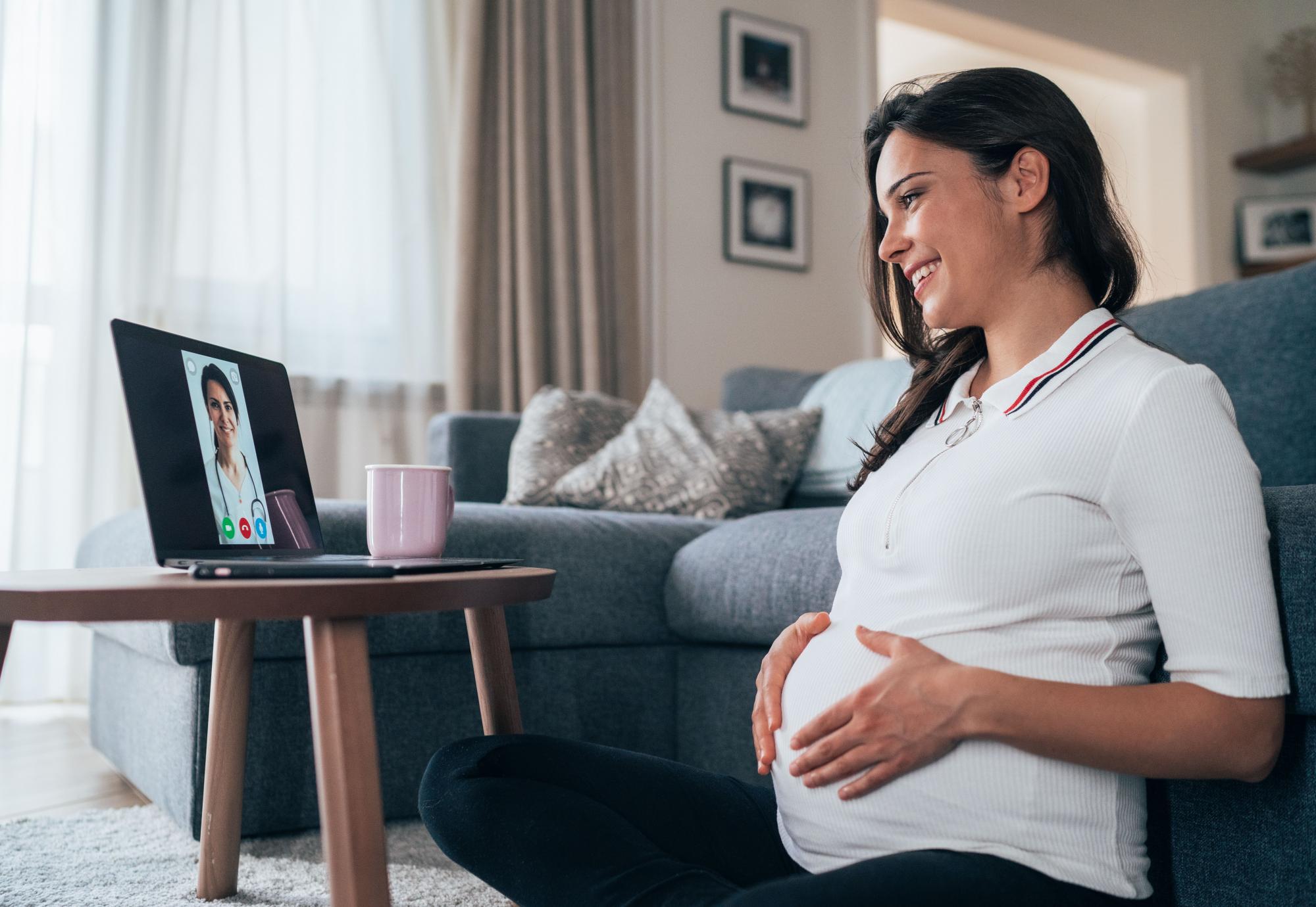 Pregnant woman talking remotely with a clinician