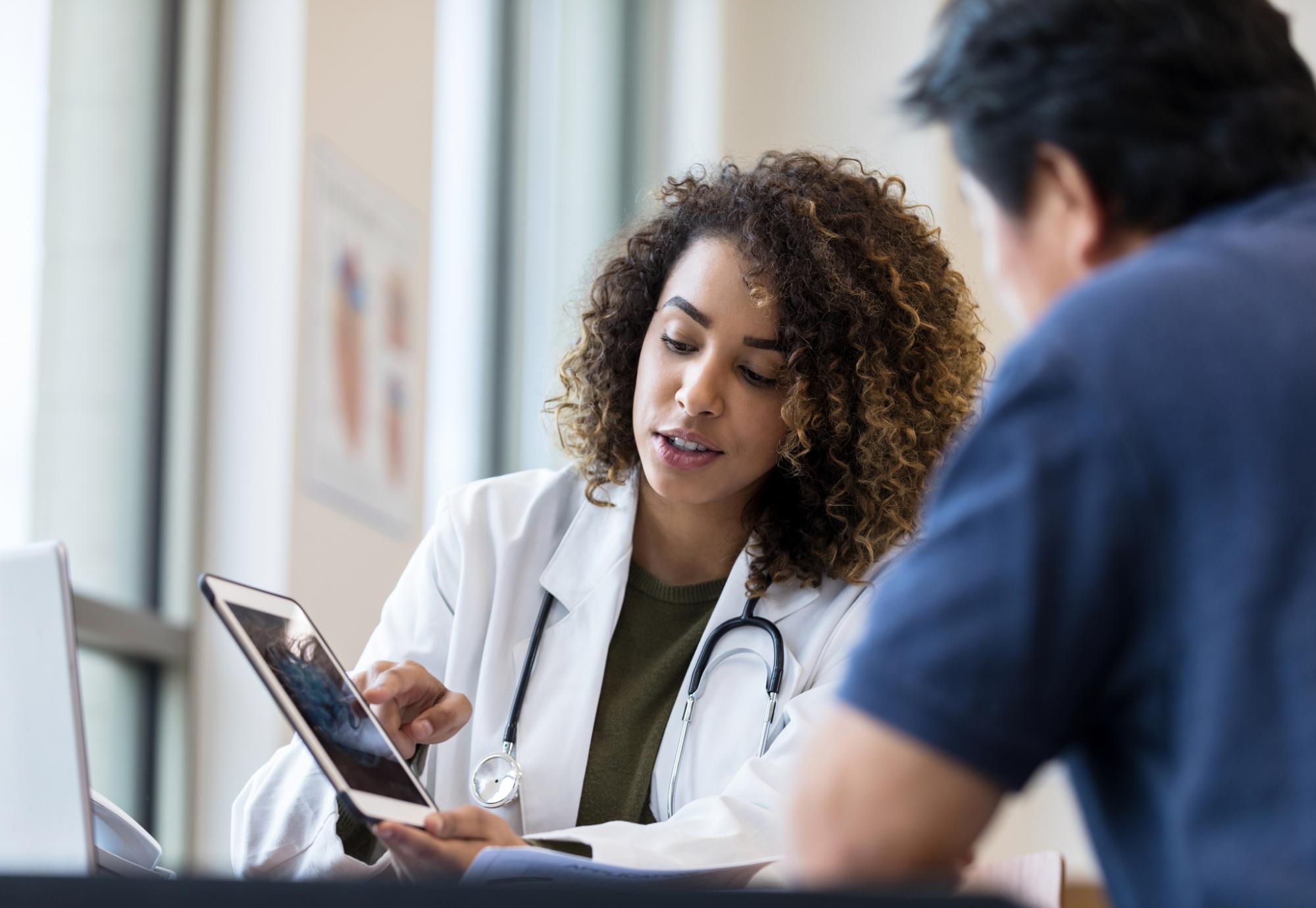 Doctor using a tablet PC to explain heart monitor results