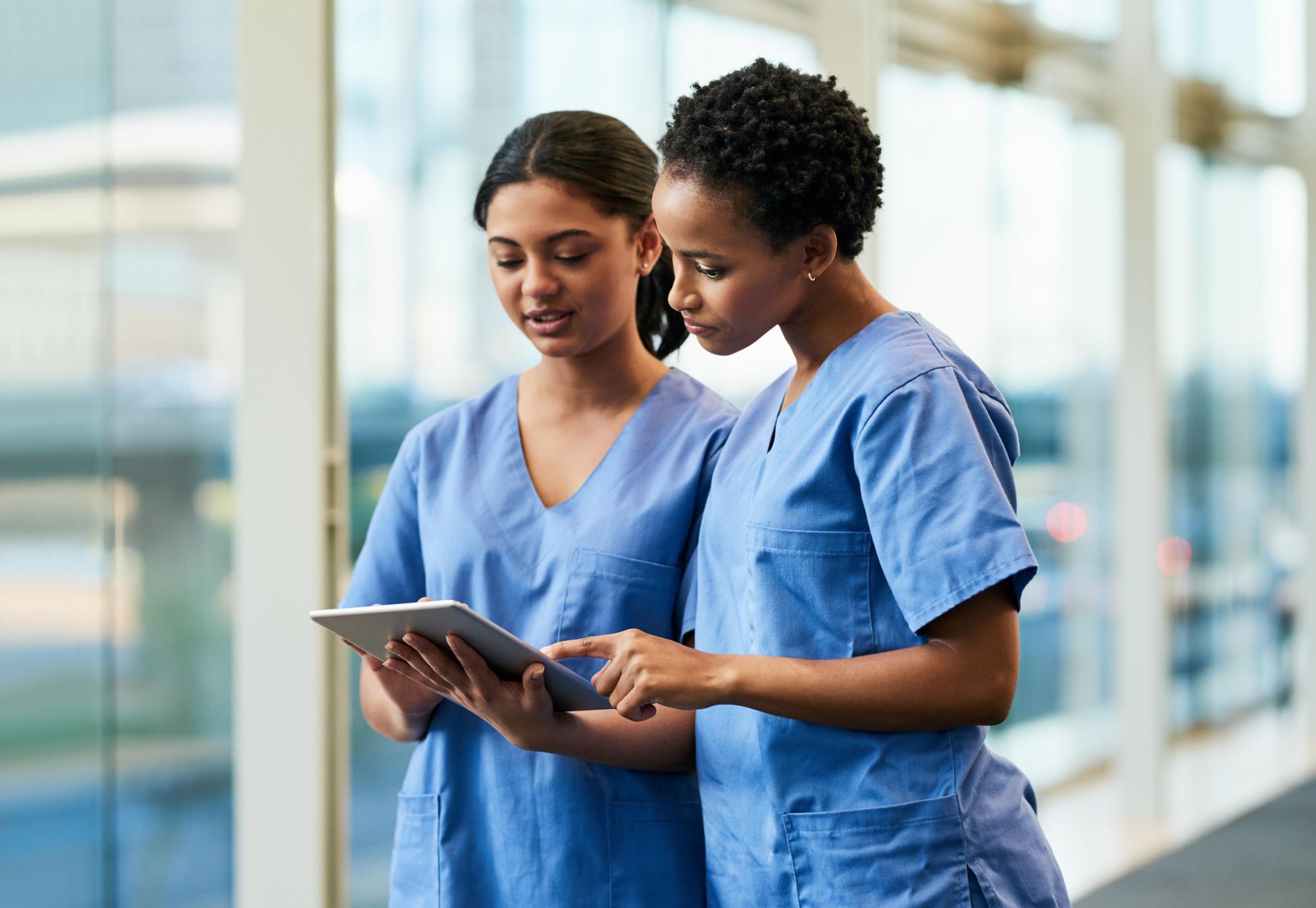 Nurses in conversation looking at a tablet PC