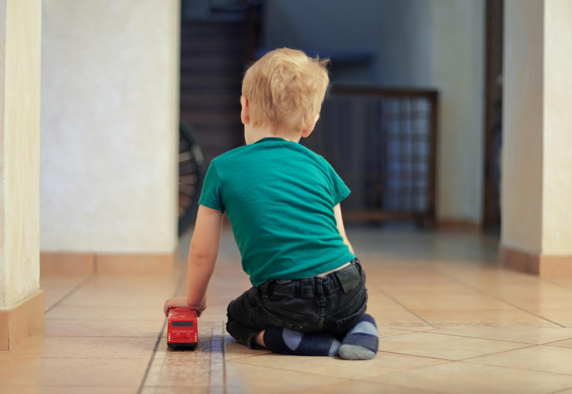 child playing with red bus toy 