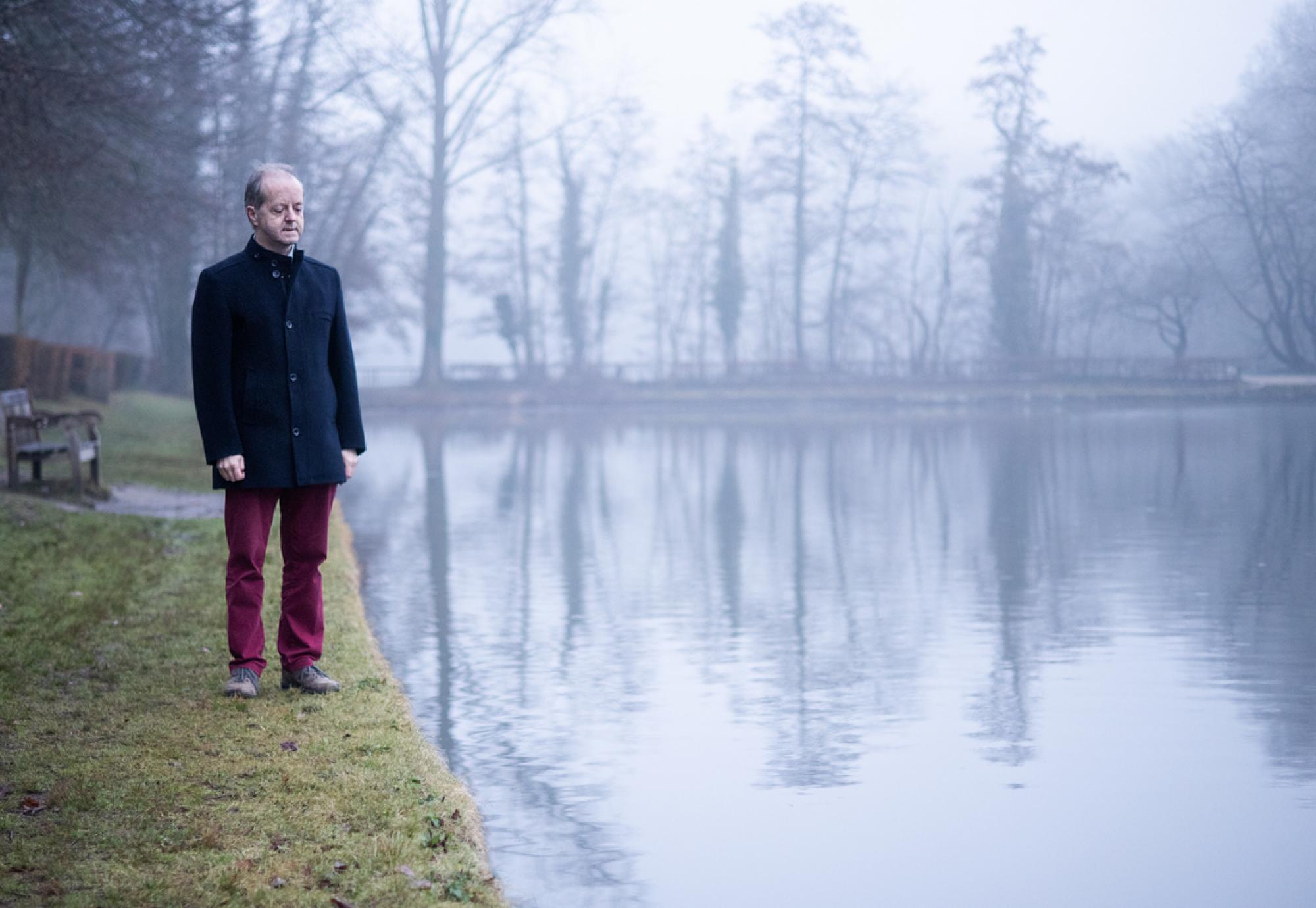 man standing near lake 