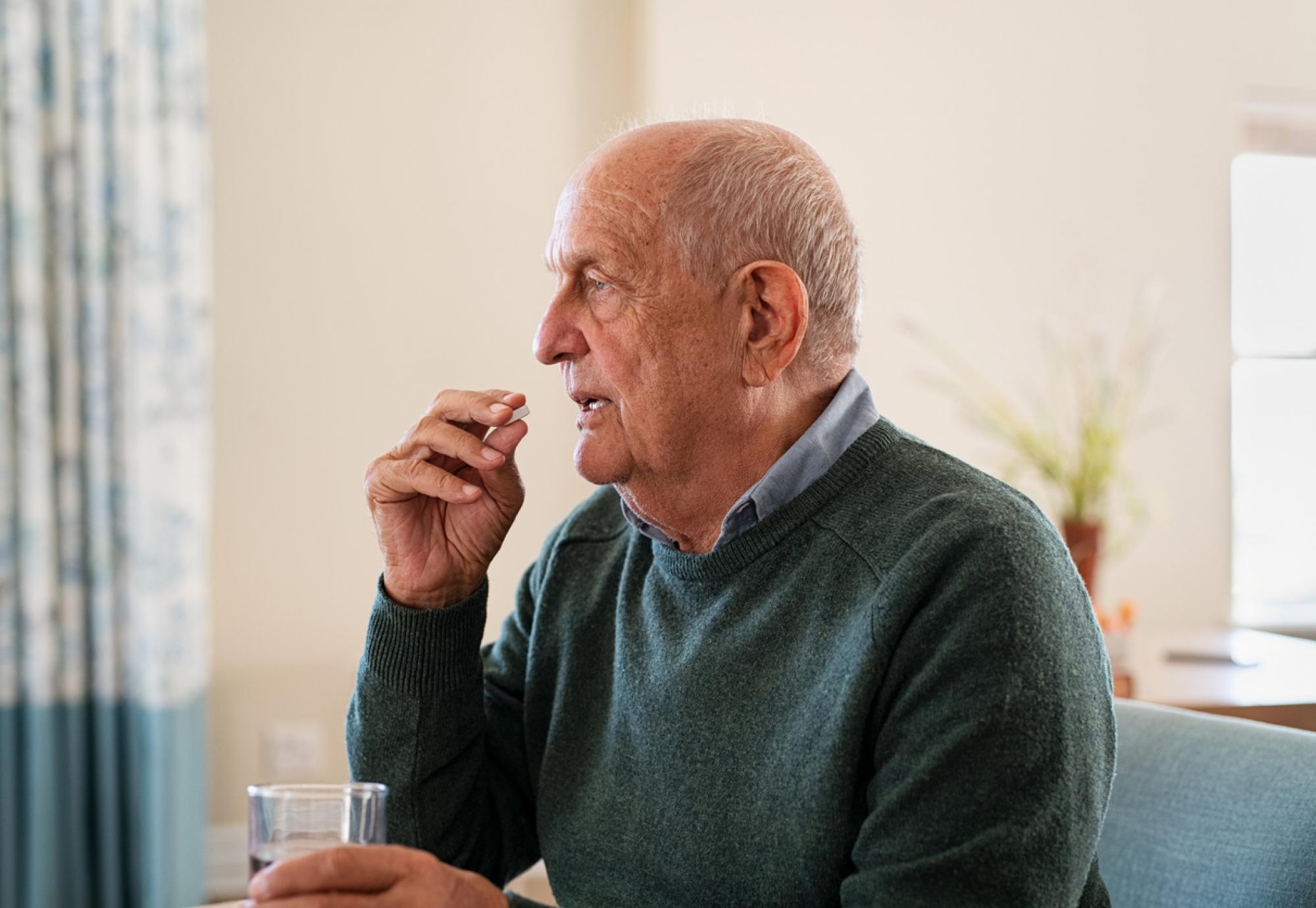 elderly man taking medication