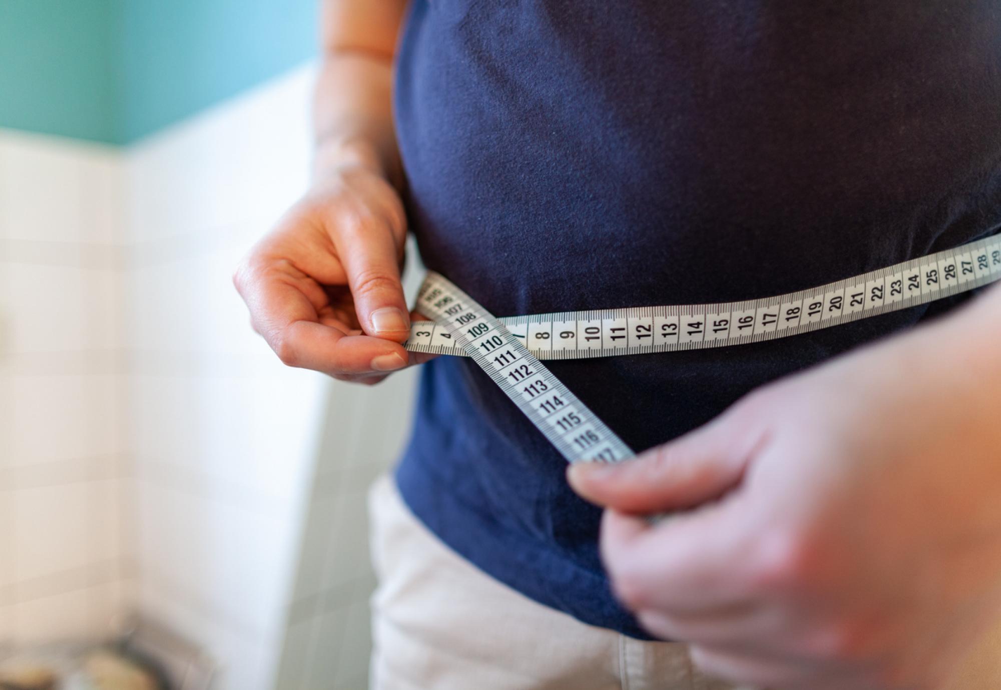 man measuring waist 