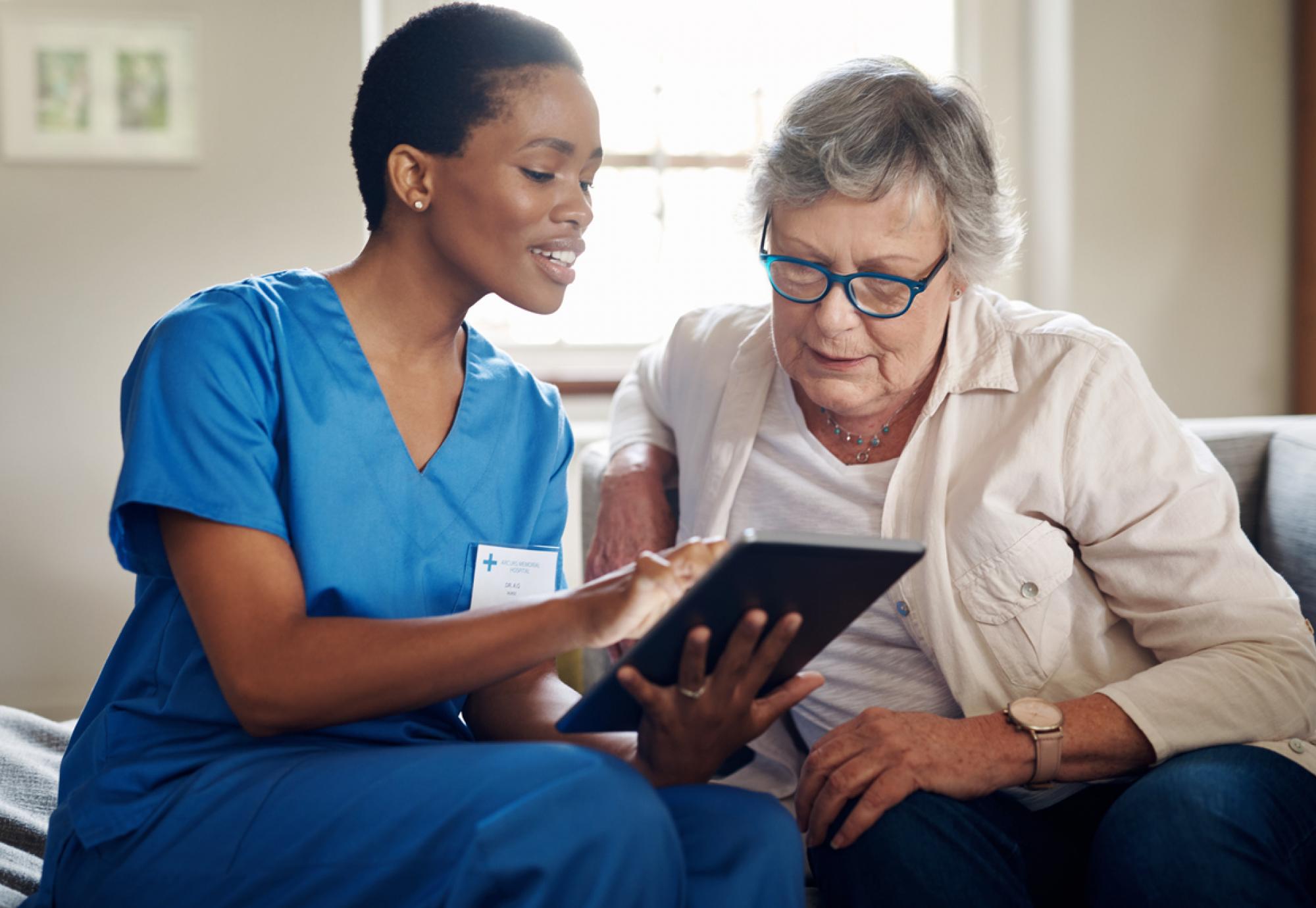 lady being helped to use ipad