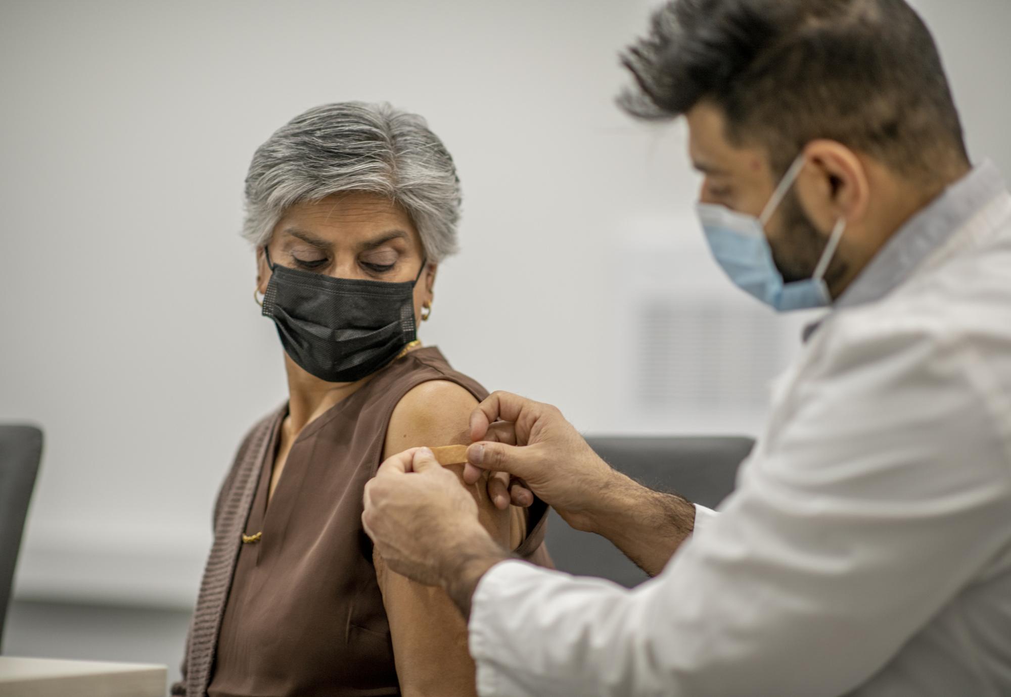 Elderly woman receiving a vaccine jab