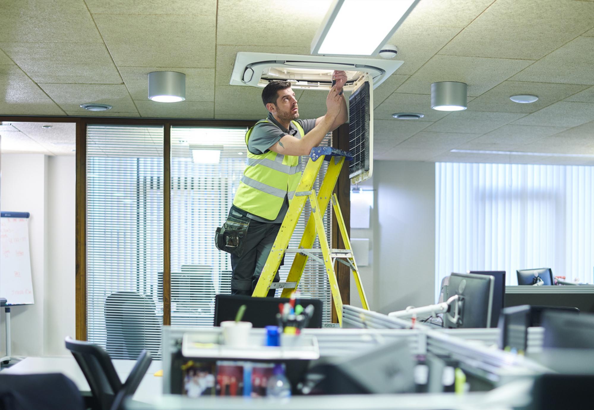 man on ladder changing lightbulb