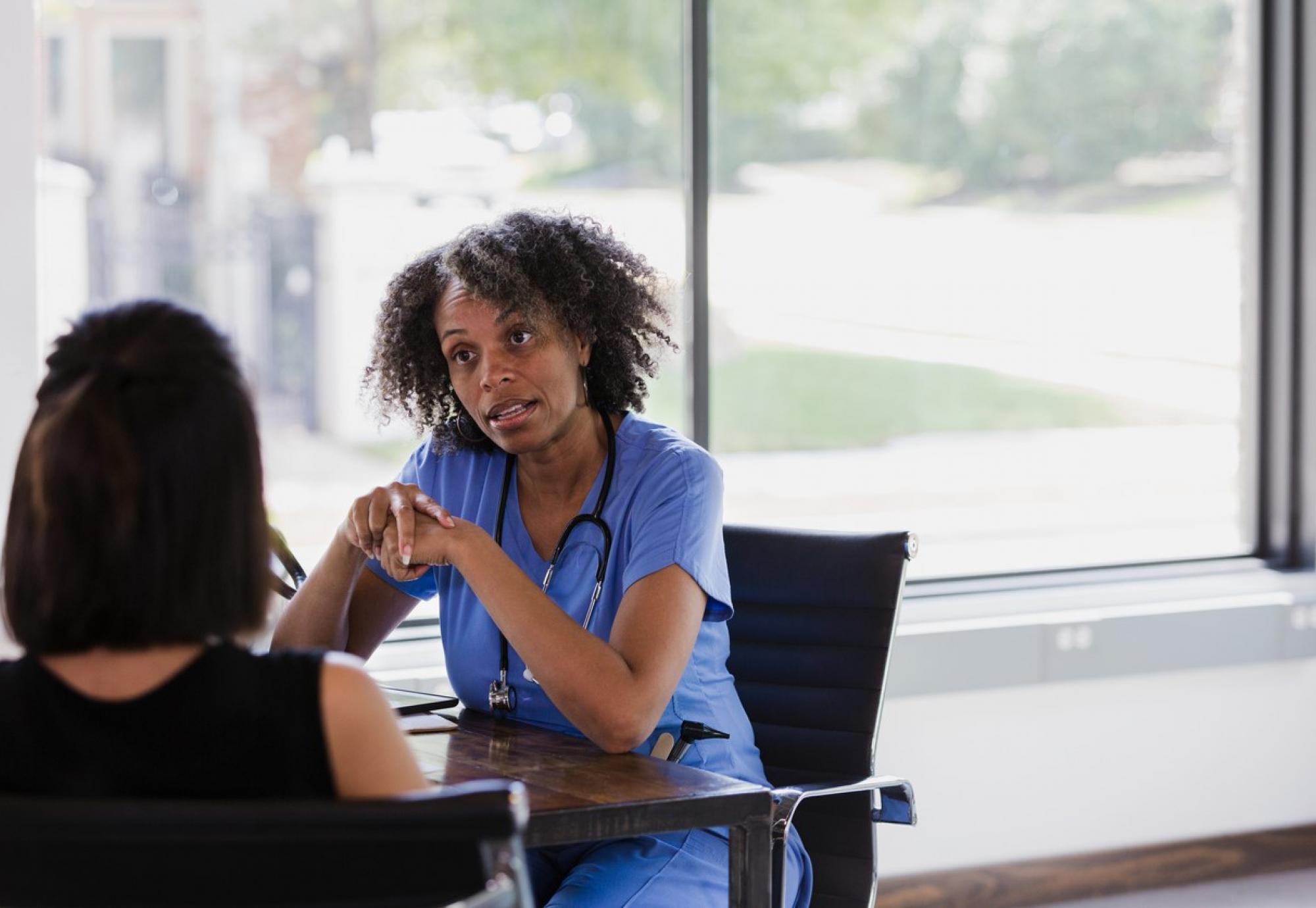 nurse talking to female patient