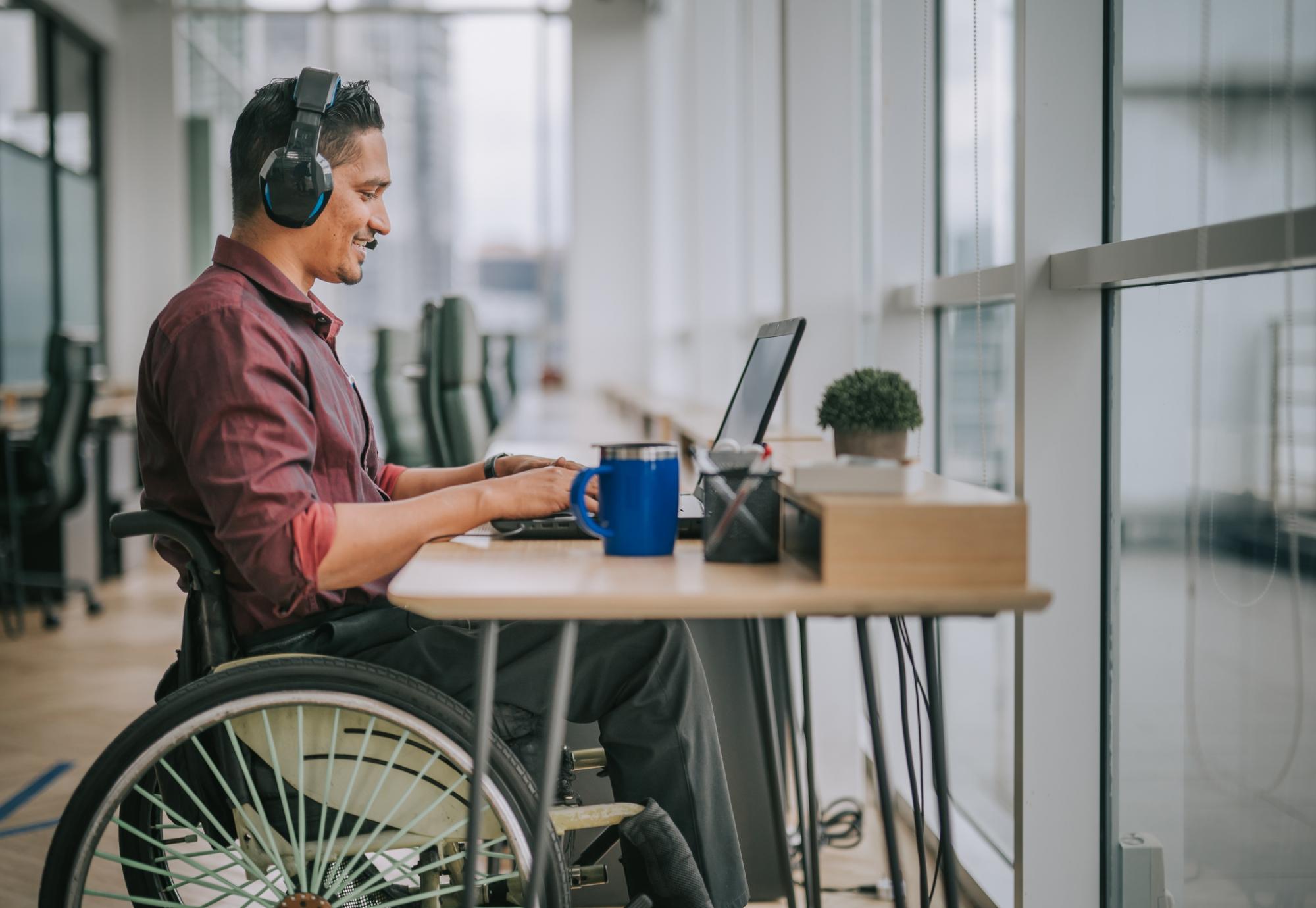 Employee in a wheelchair using a computer at his desk