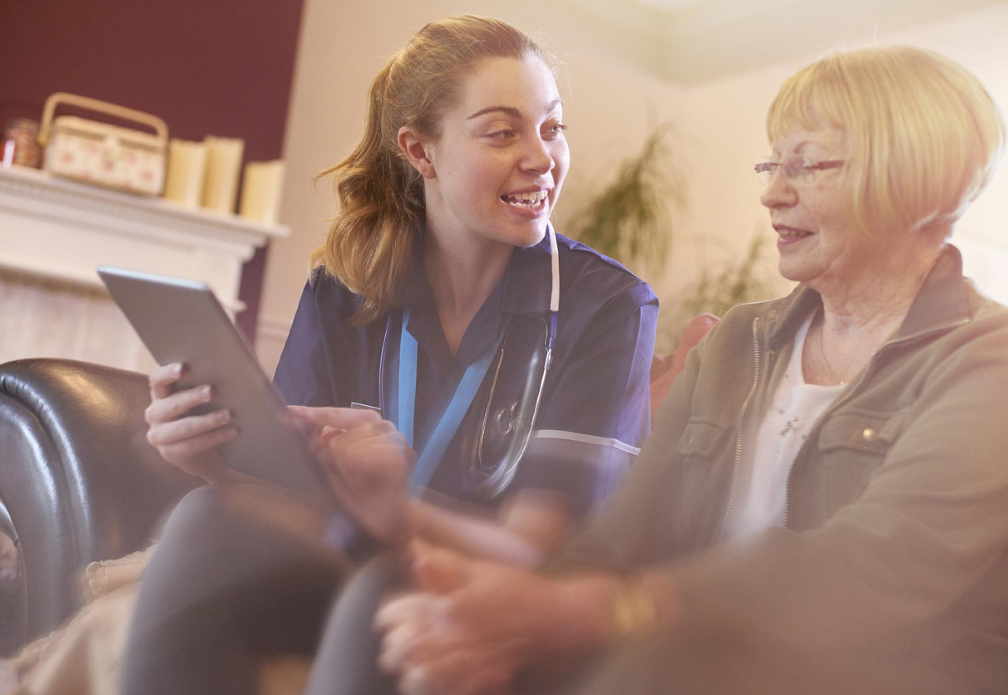 dementia patient using tablet with nurse
