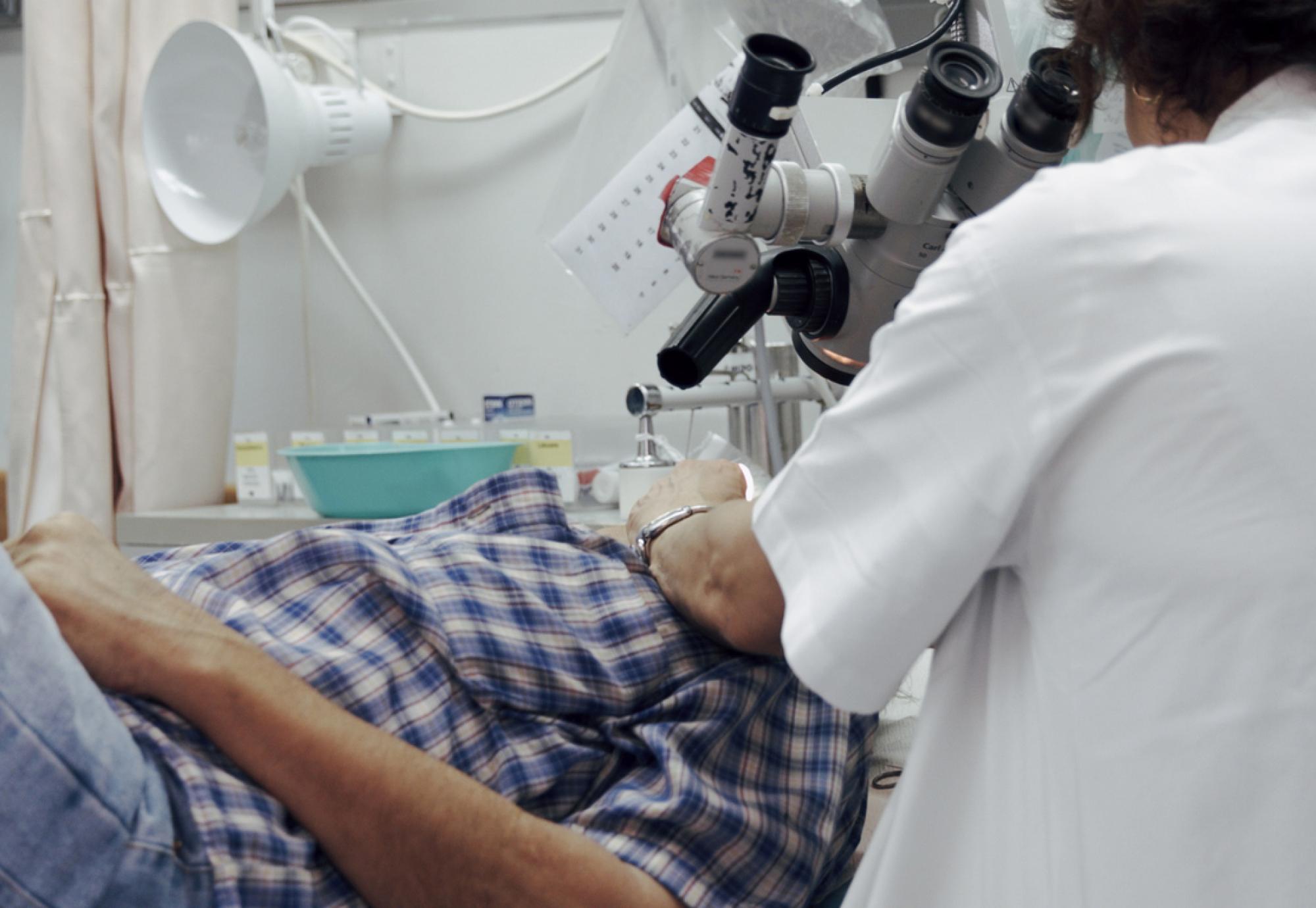 Doctor looking at patient through microscope