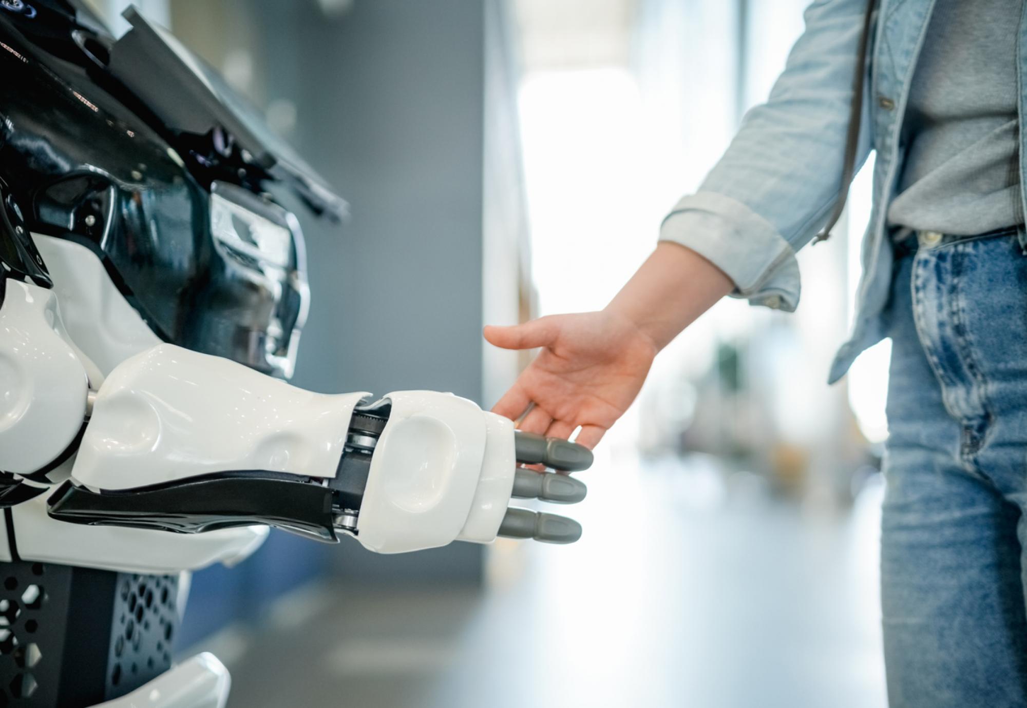 Woman shaking robotic hand