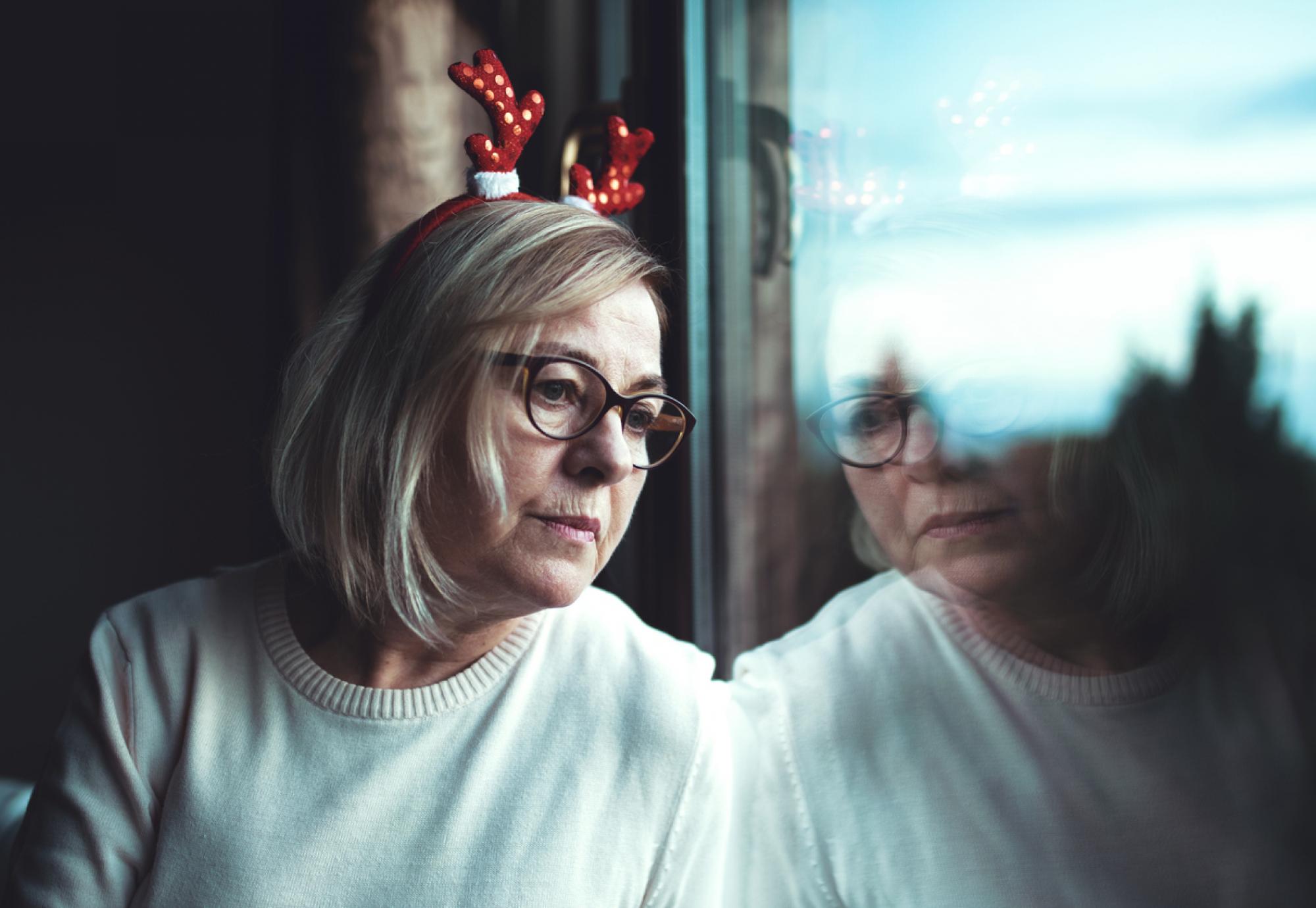 A lonely woman looking out of a window