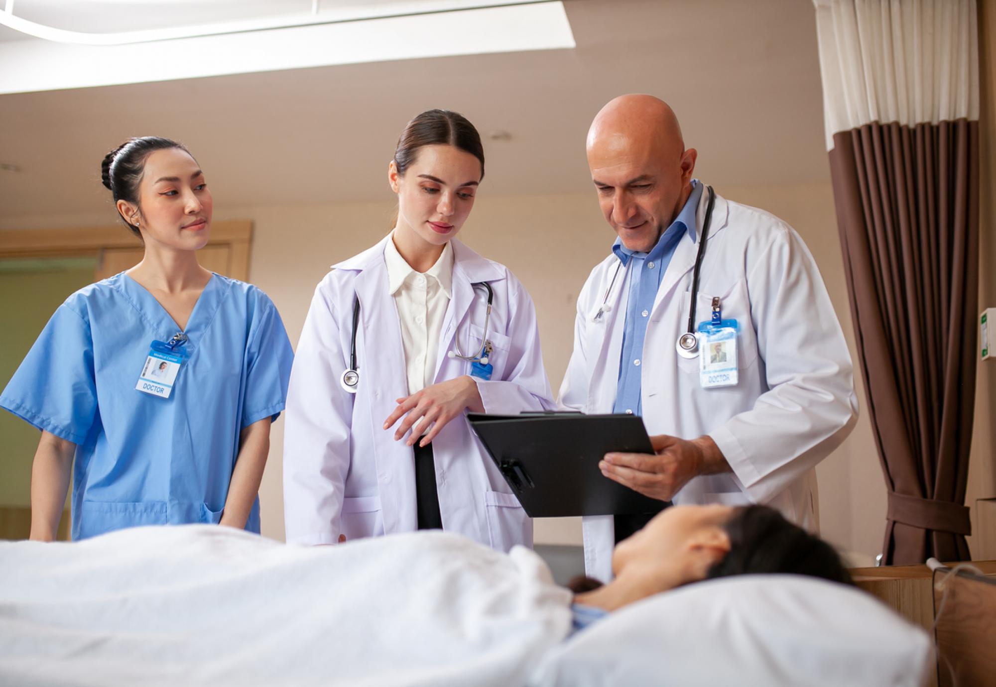 One male and two female doctors with patient