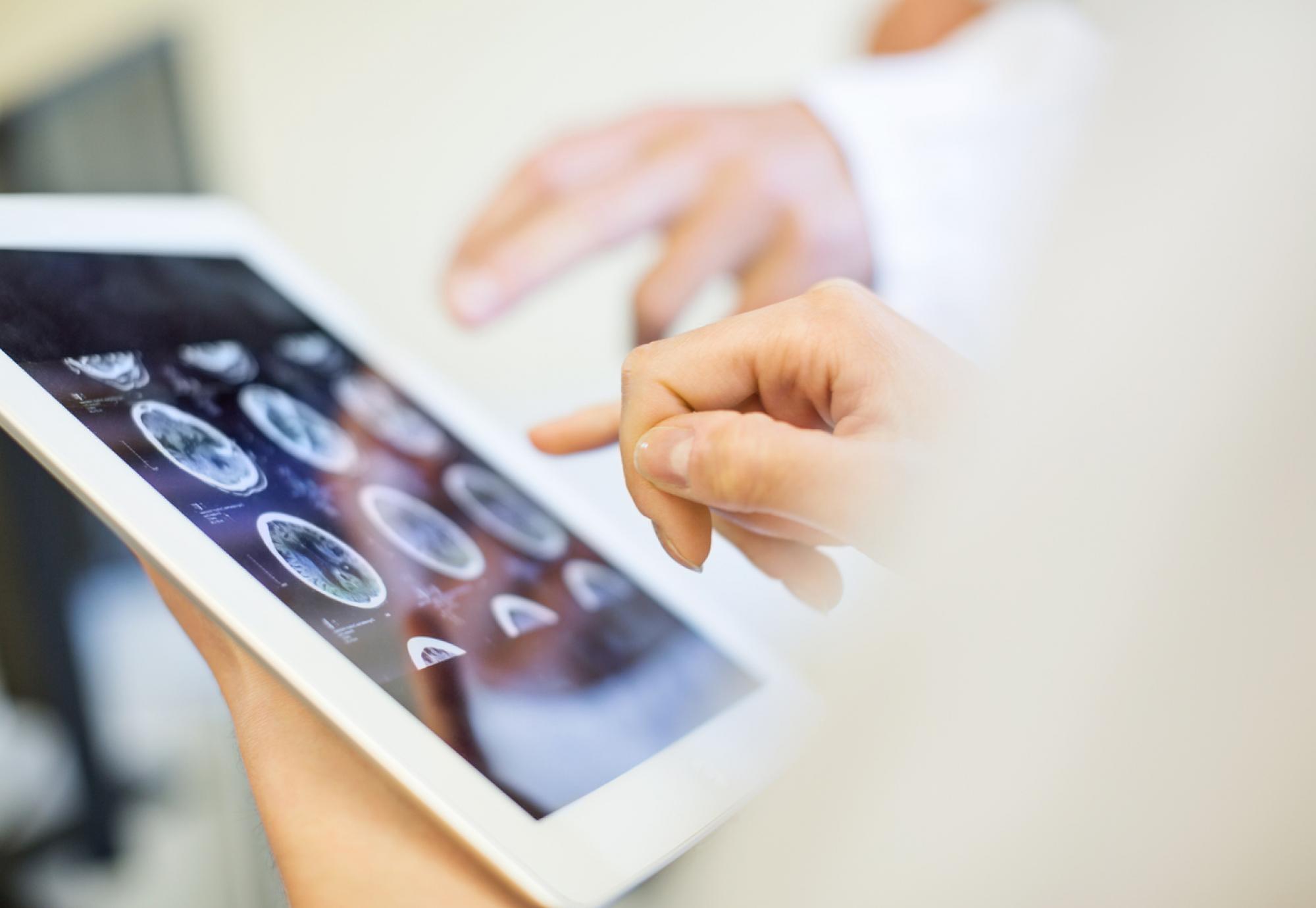 Medical team analysing MRI scans on digital tablet